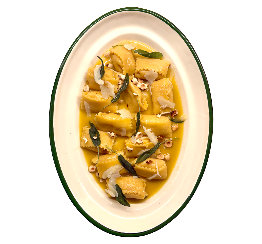 Oval plate of golden butter-sauced pasta with sage leaves, chili flakes, and grated cheese on white background.