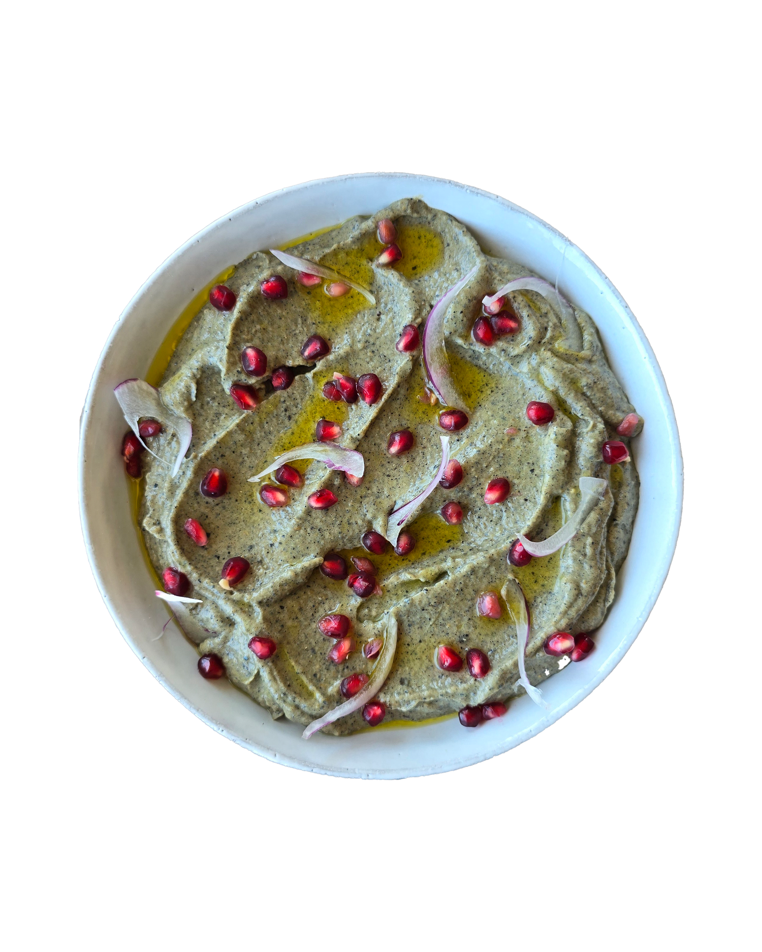 Creamy green herb hummus topped with pomegranate seeds and sliced onions in white bowl.