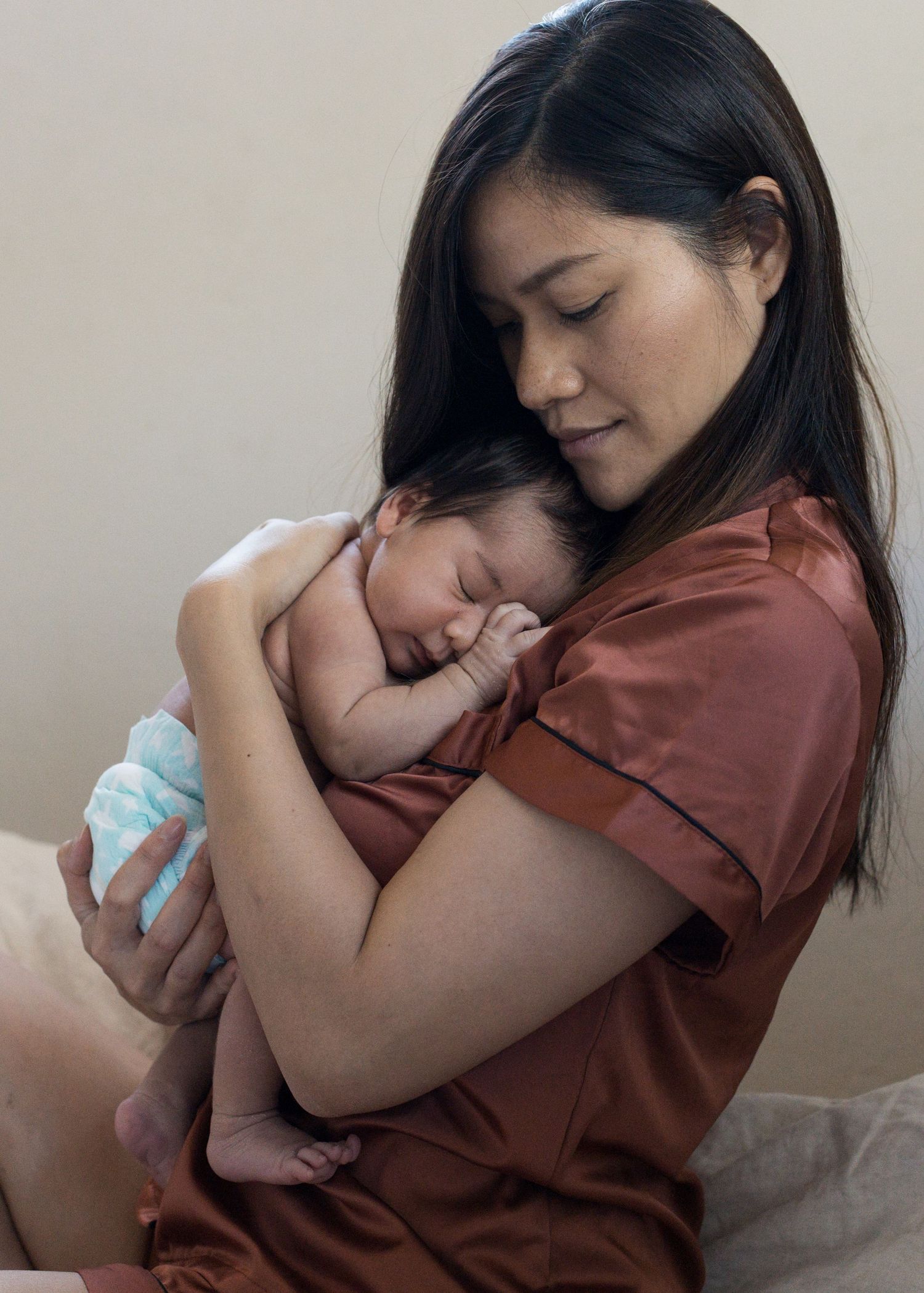 Mother holding her newborn baby during an in-home lifestyle session in Atascadero