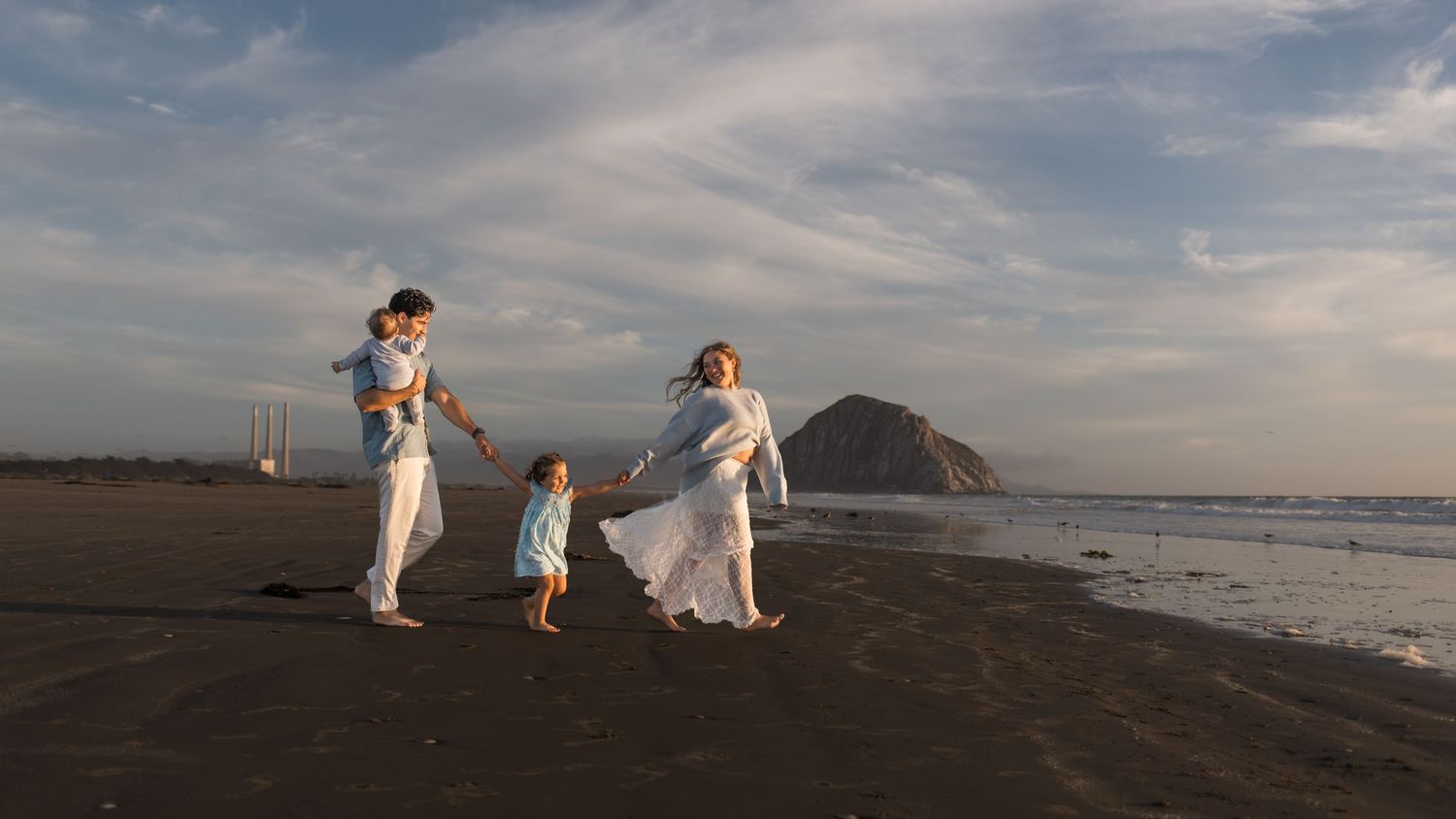 Family walking along the beach during a natural family photography session in Morro Bay, California.