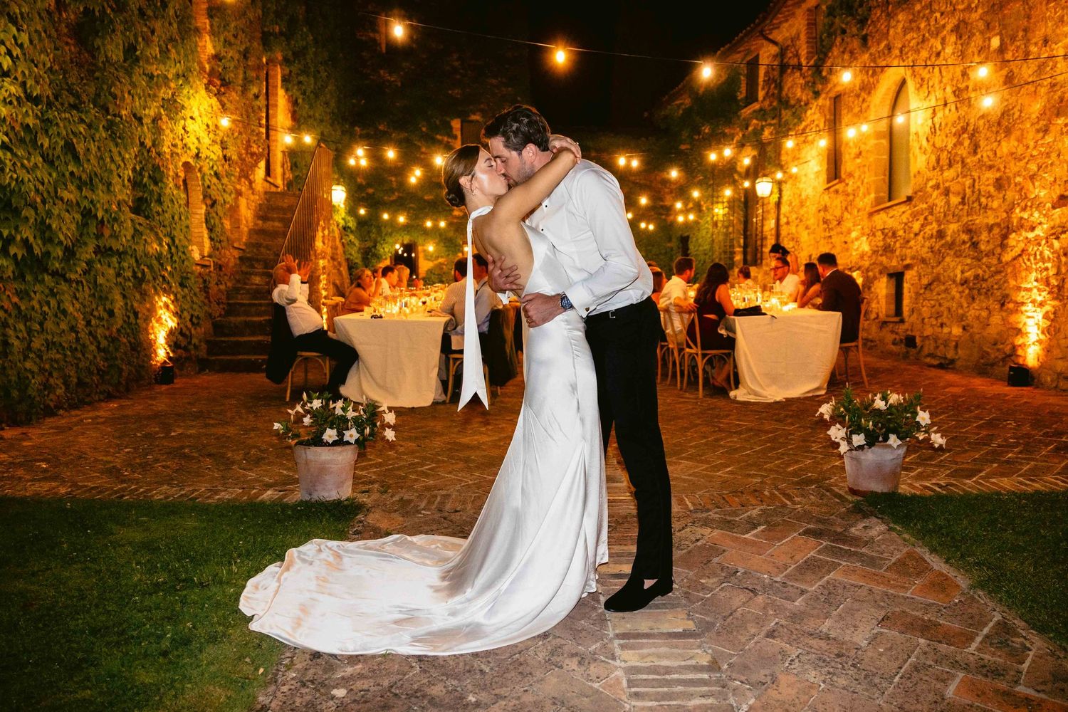 Küssendes Hochzeitspaar abends am Tag der Hochzeit im Freien in der Toskana - aufgenommen vom Hochzeitsfotograf aus Hannover