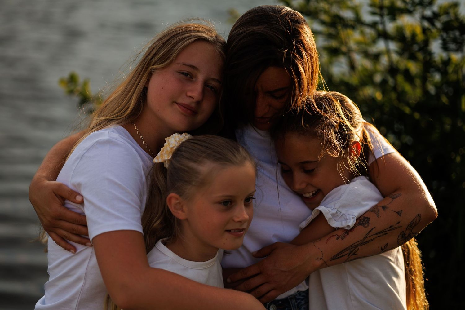 Gros câlins pour cette mère et ses filles lors d'une séance famille au couché de soleil à Seclin