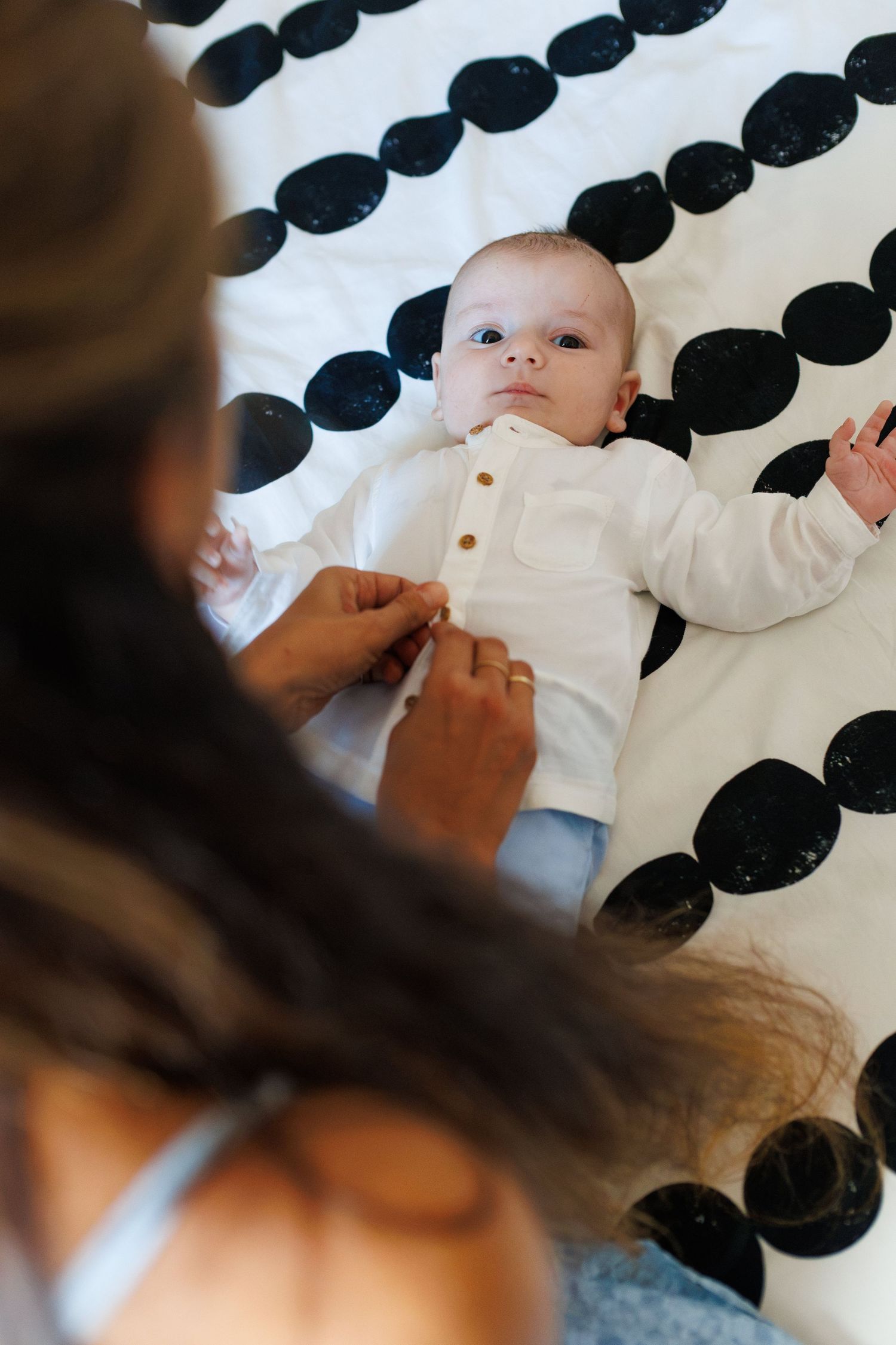 Photographie habillage d'un enfant avant son baptême