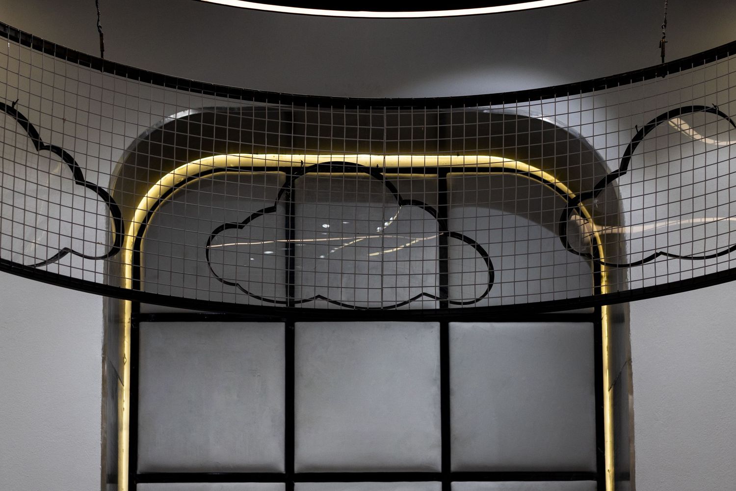 Dramatic retail store ceiling featuring black metal grid with cloud-shaped neon light outlines and golden arched frame.