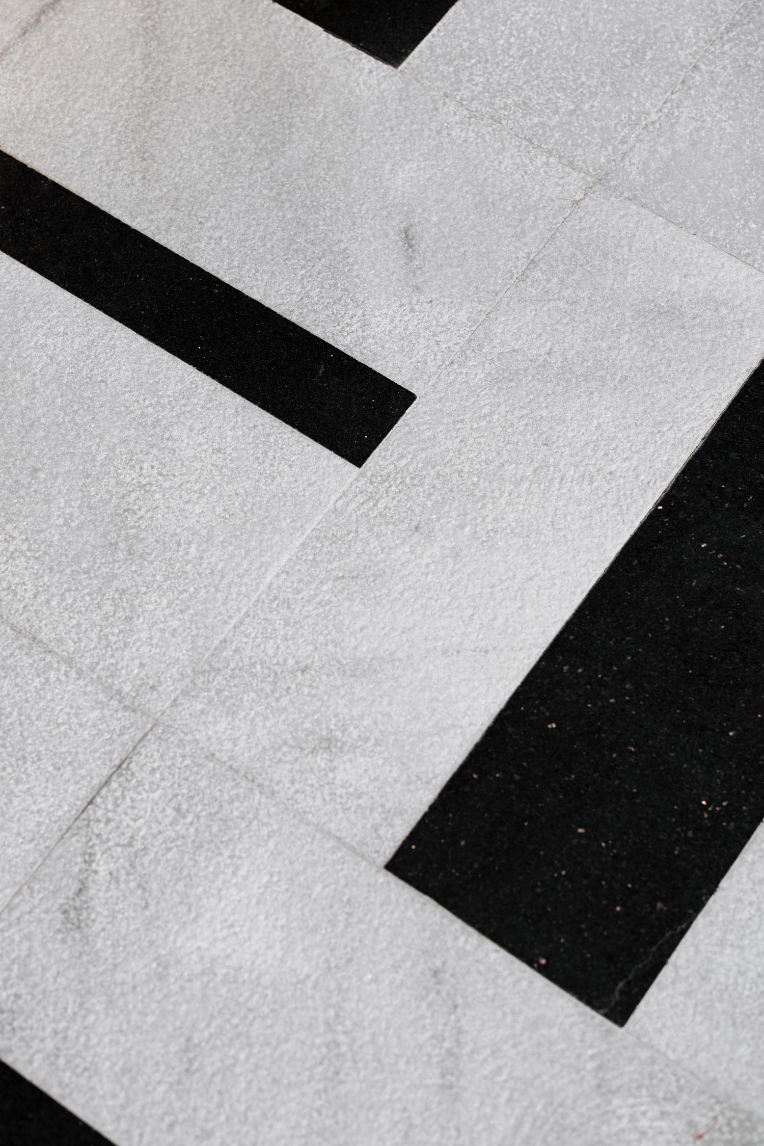 Close-up of black and white geometric marble floor tiles with angular pattern.