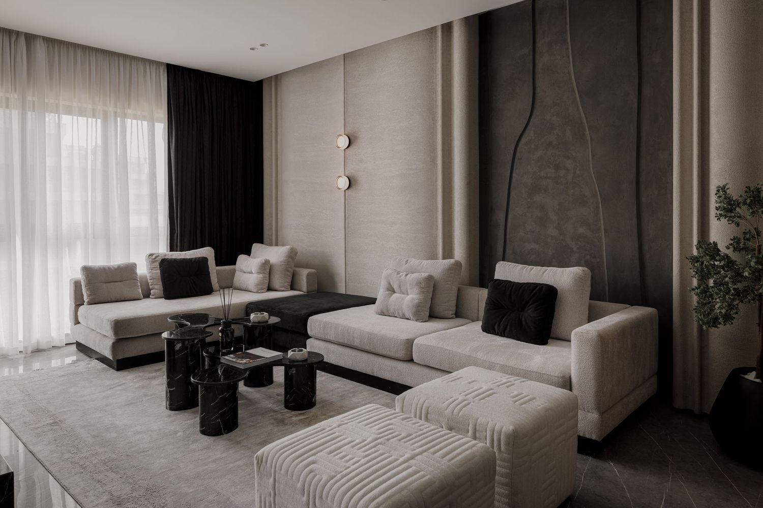 Contemporary living room with beige modular sofas, black marble coffee tables, and textured wall panels.