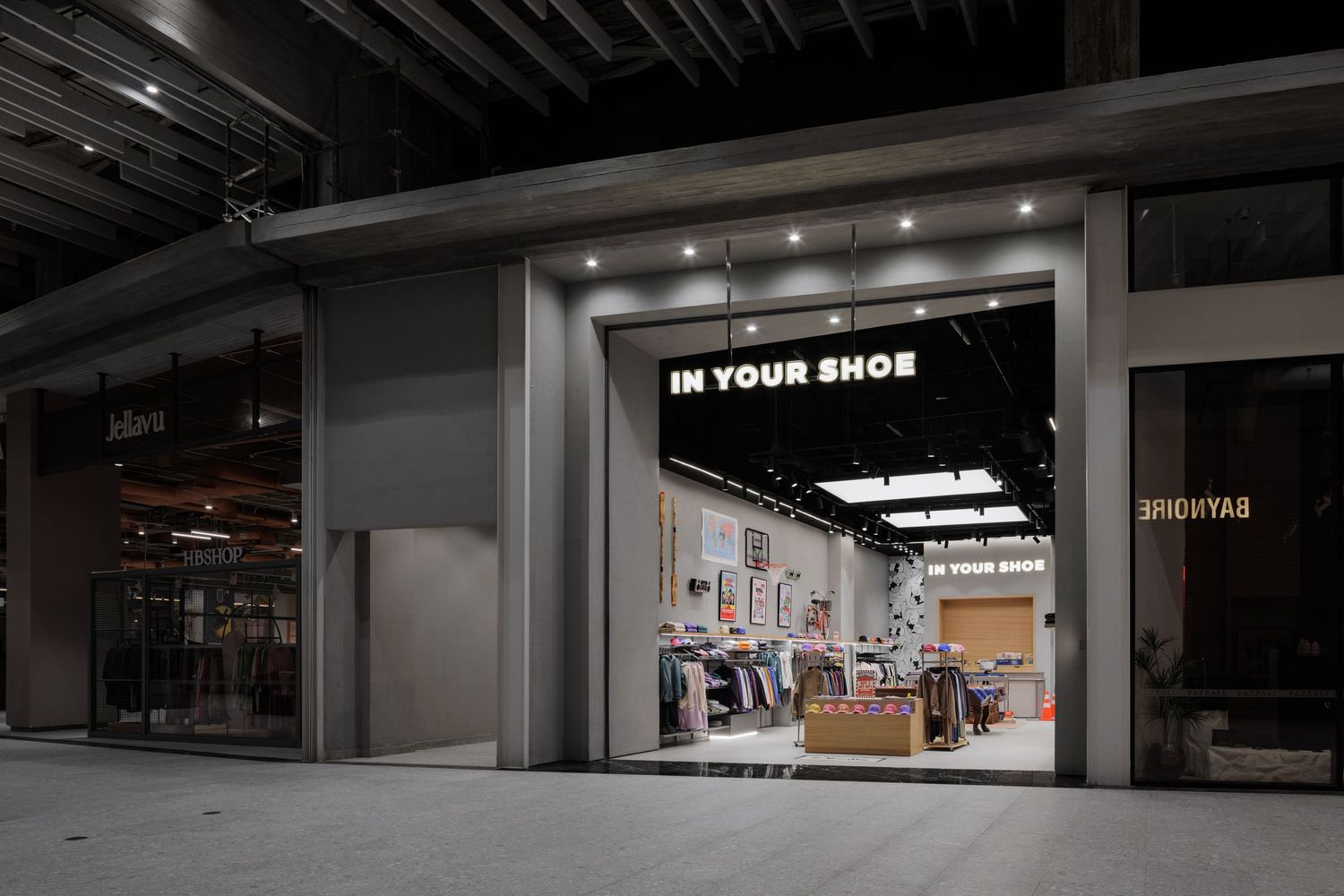 In Your Shoe streetwear store exterior with bright signage at night in a shopping center.
