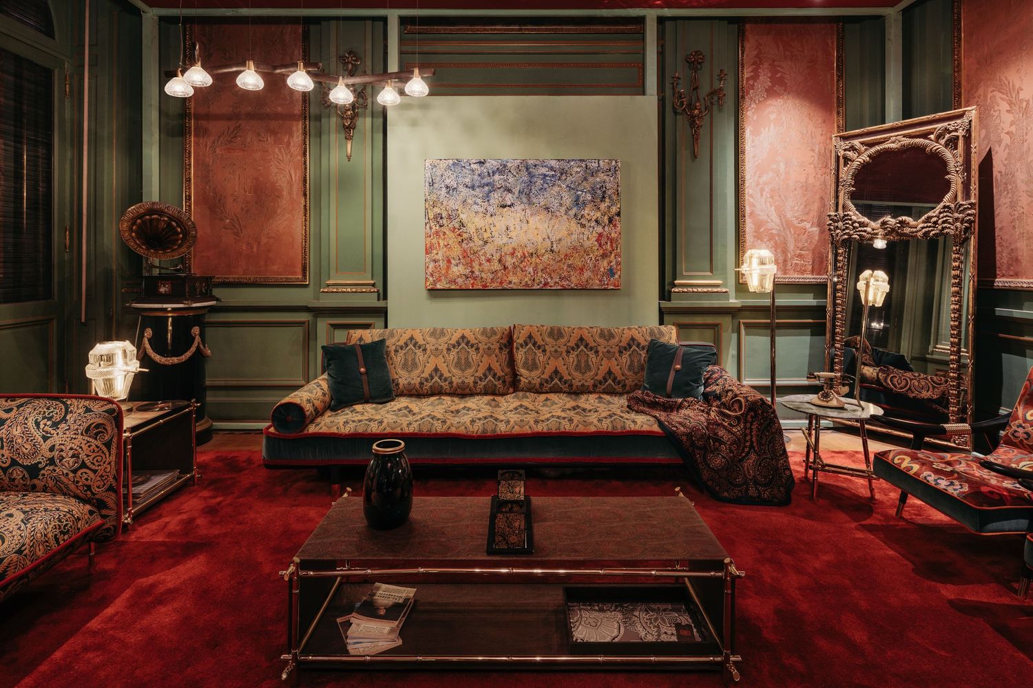 Opulent living room with rich red velvet carpet, ornate patterned sofa, green walls, and abstract wall painting.