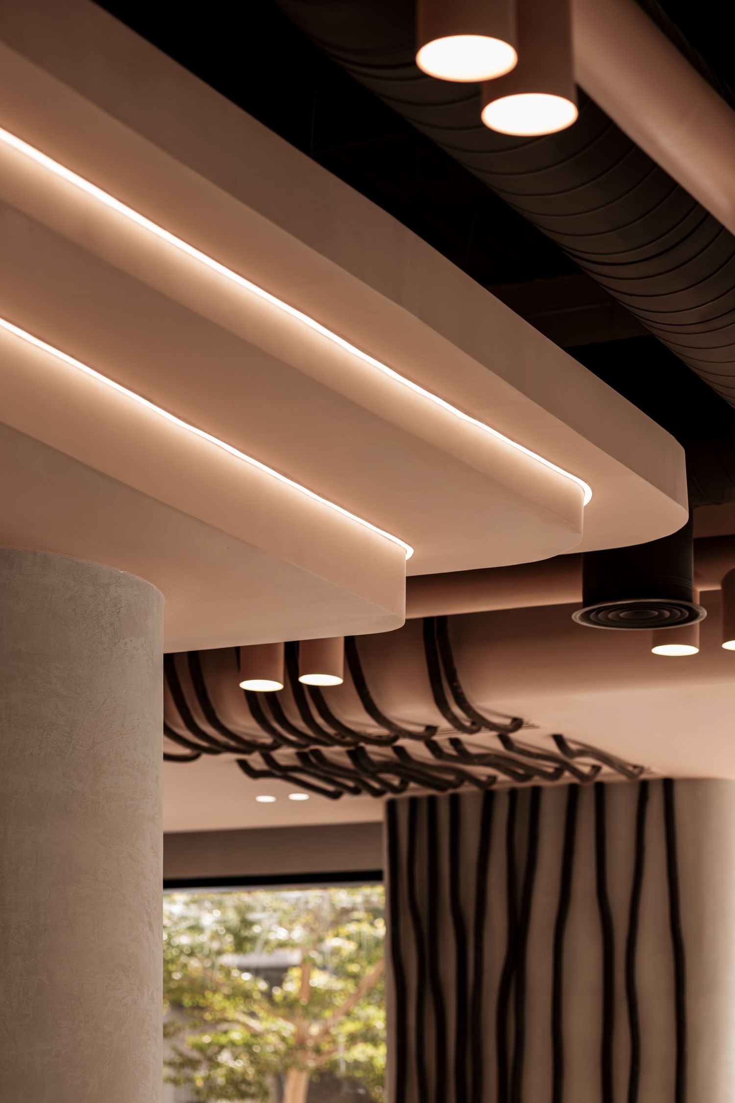 Modern ceiling design with LED strip lighting, round spotlights, and wavy dark decorative elements.