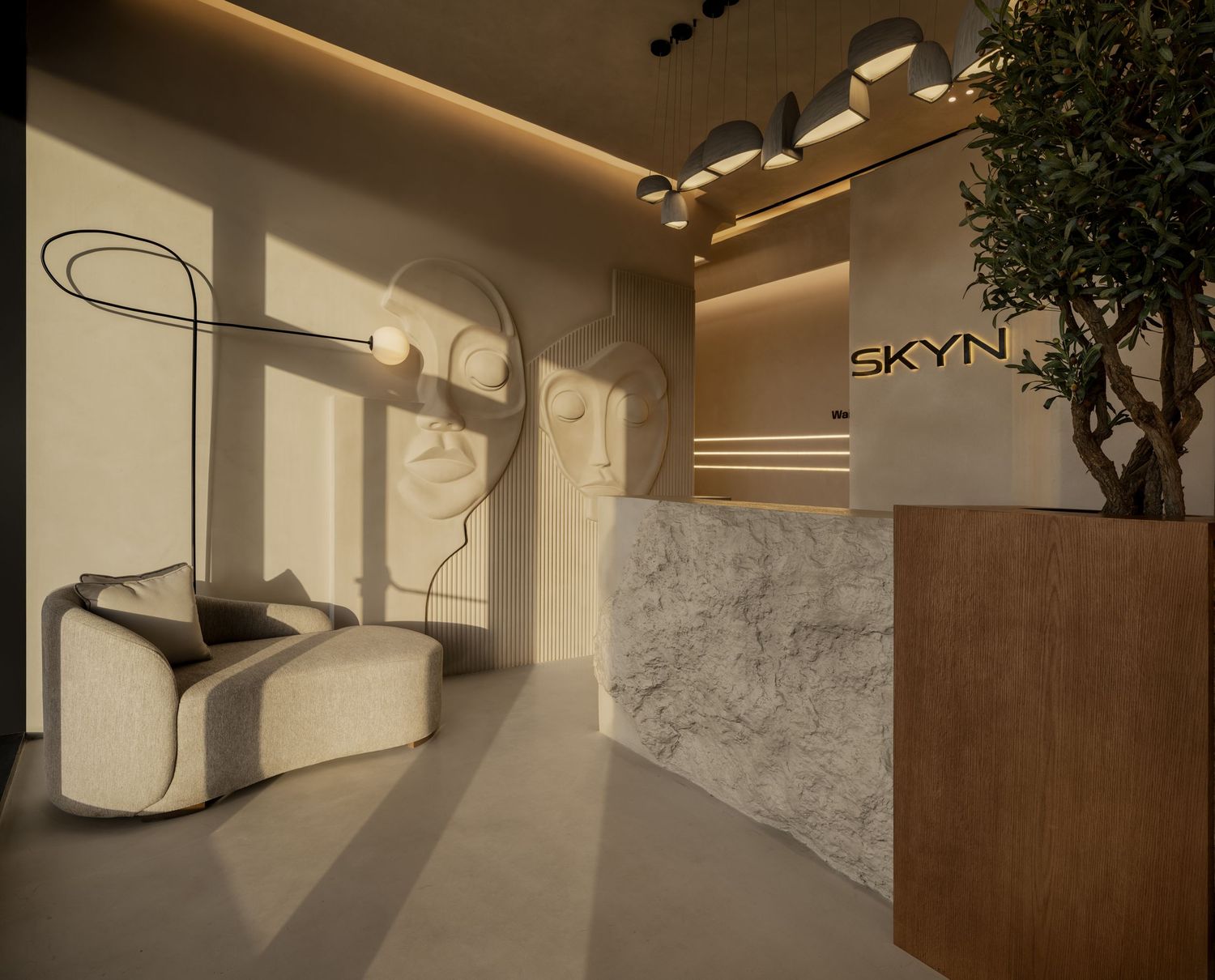 Modern minimalist spa reception with marble desk, abstract face wall art, and curved chair in neutral tones.