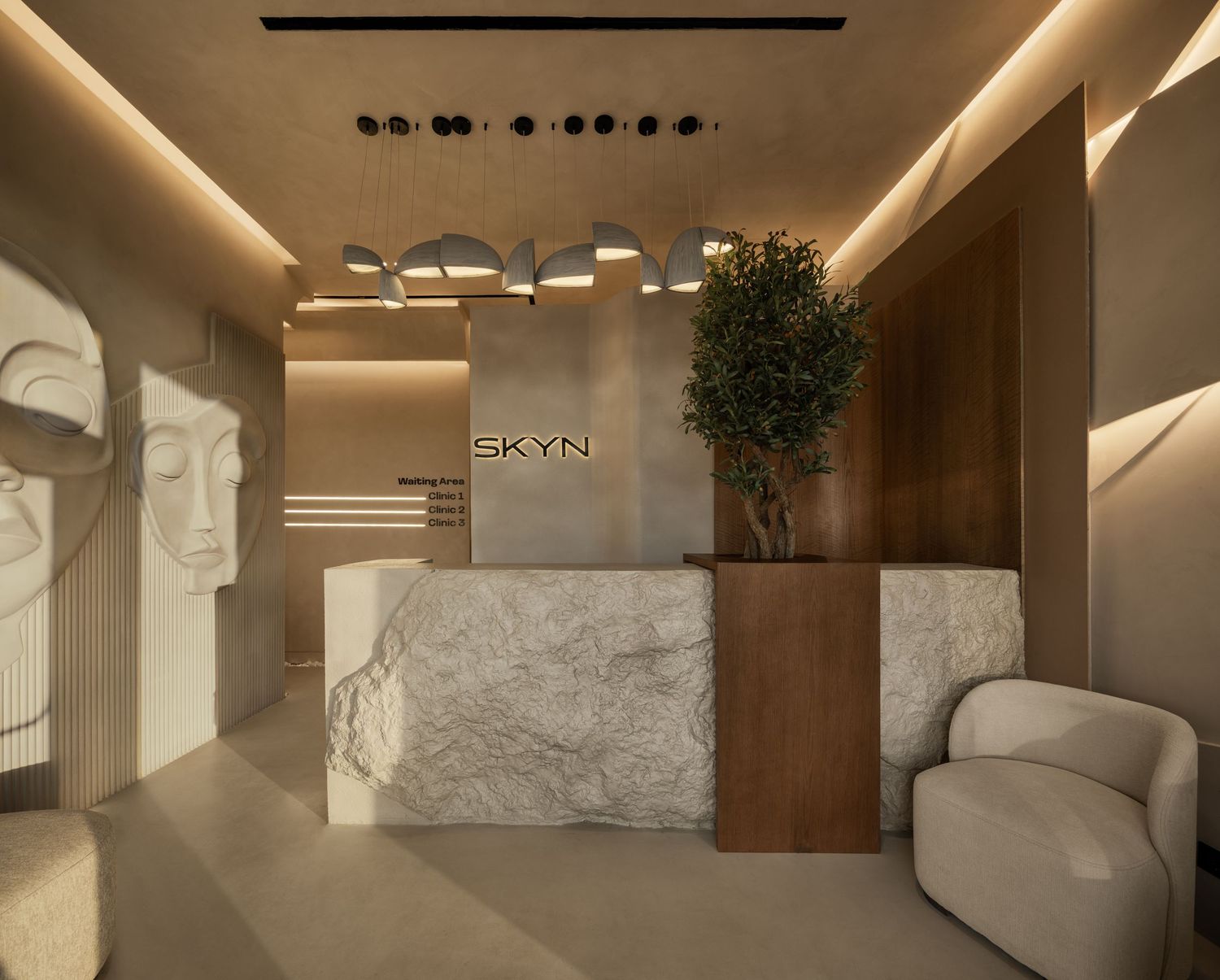 Modern luxury reception area with marble desk, warm lighting, indoor tree, and SKYN branding on wooden wall.