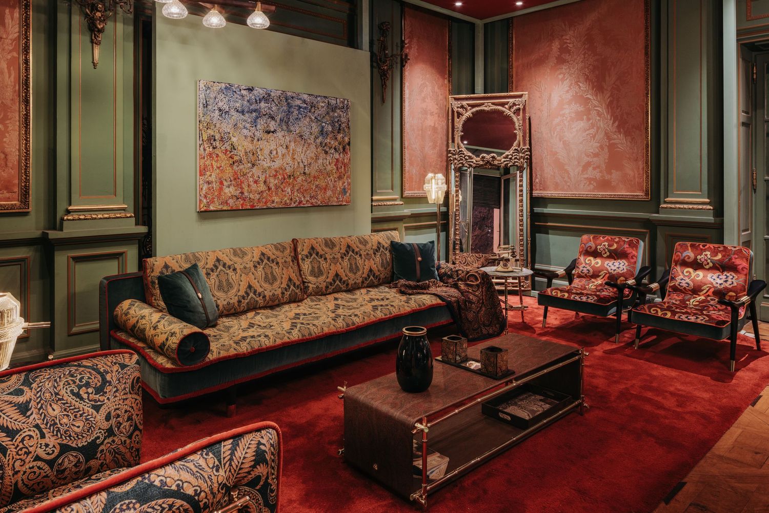 Luxurious living room with patterned furniture, red carpet, green walls, and abstract art.