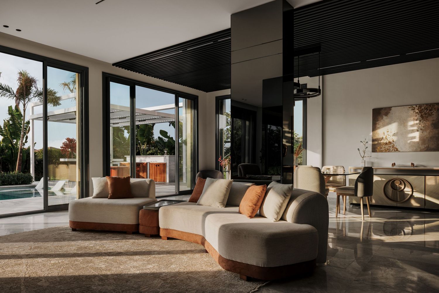 Bright modern living room with curved sofa, orange accent cushions, dark ceiling, and glass doors to pool.