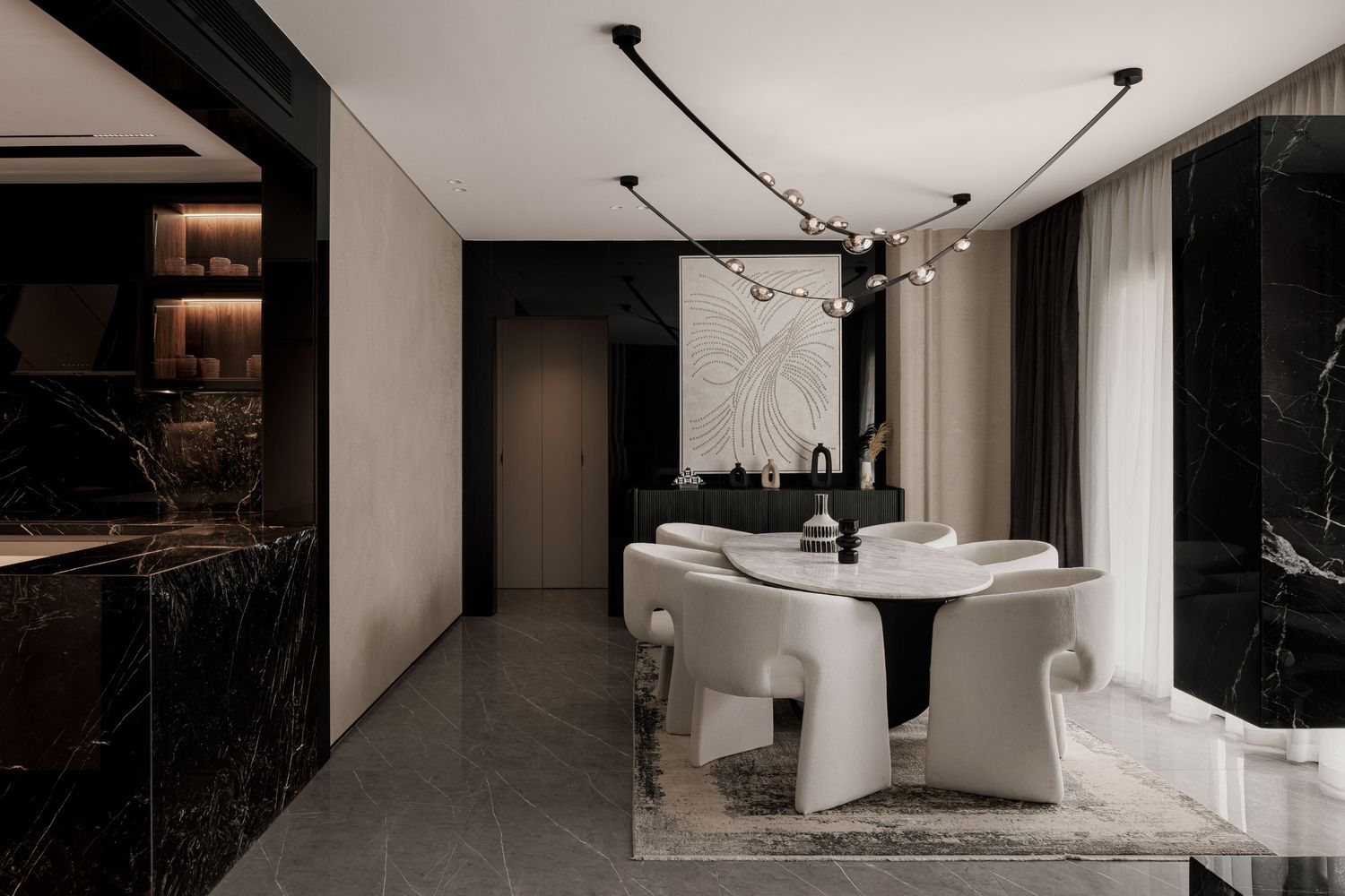 Modern dining room with white curved chairs, round marble table, black marble accents and pendant lighting.