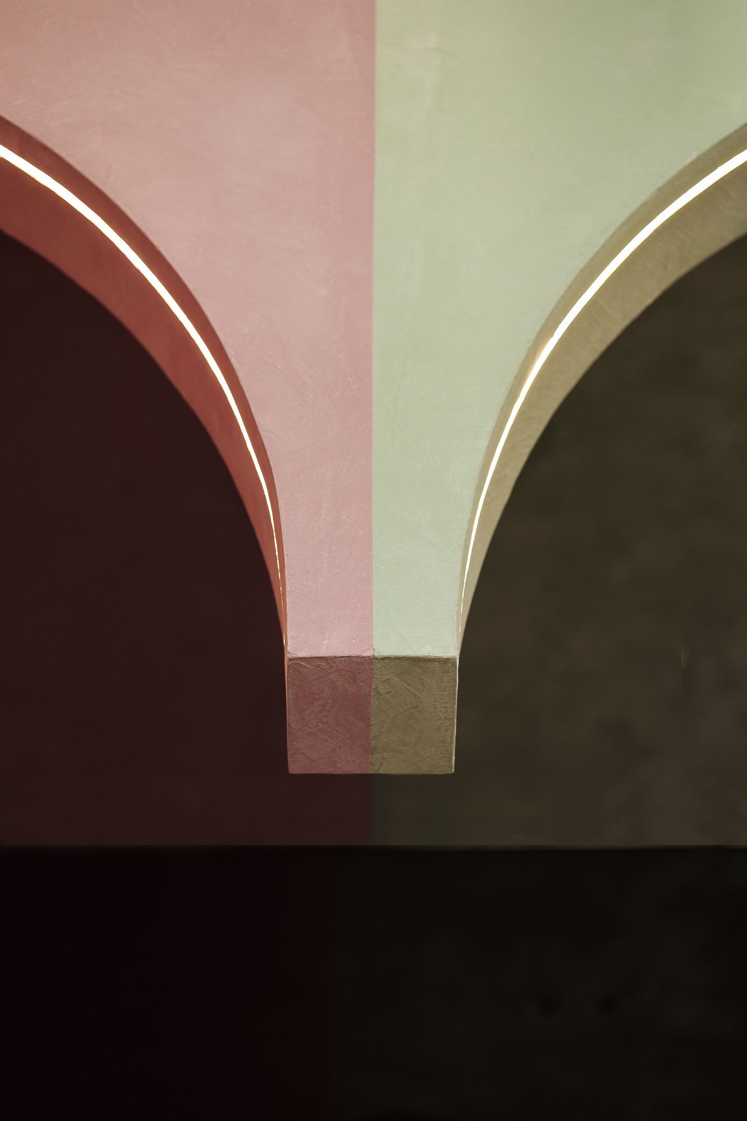 Two arched doorways in contrasting pink and sage green with gold trim accents.