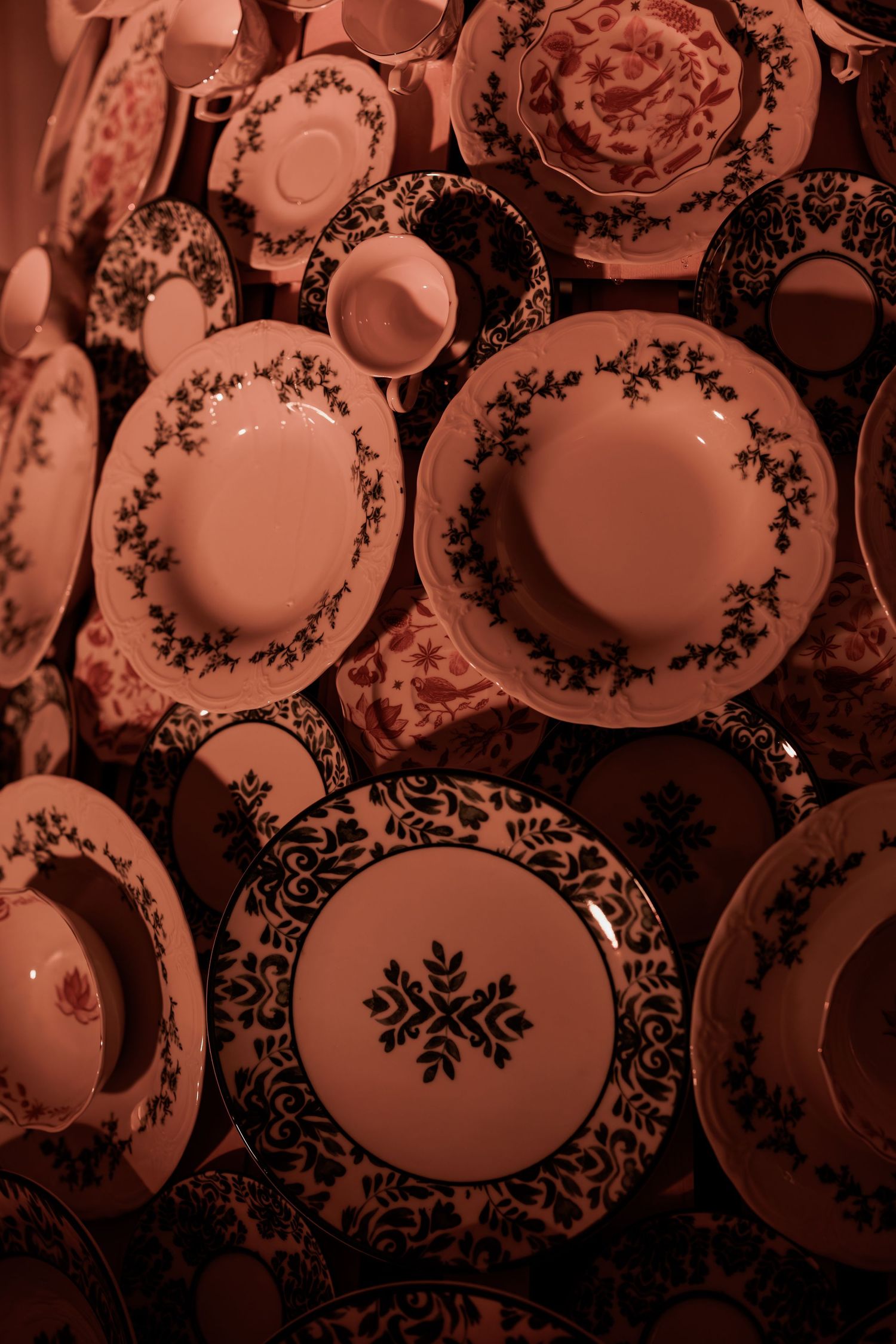 Decorative white china plates with floral and snowflake patterns mounted on a display wall.