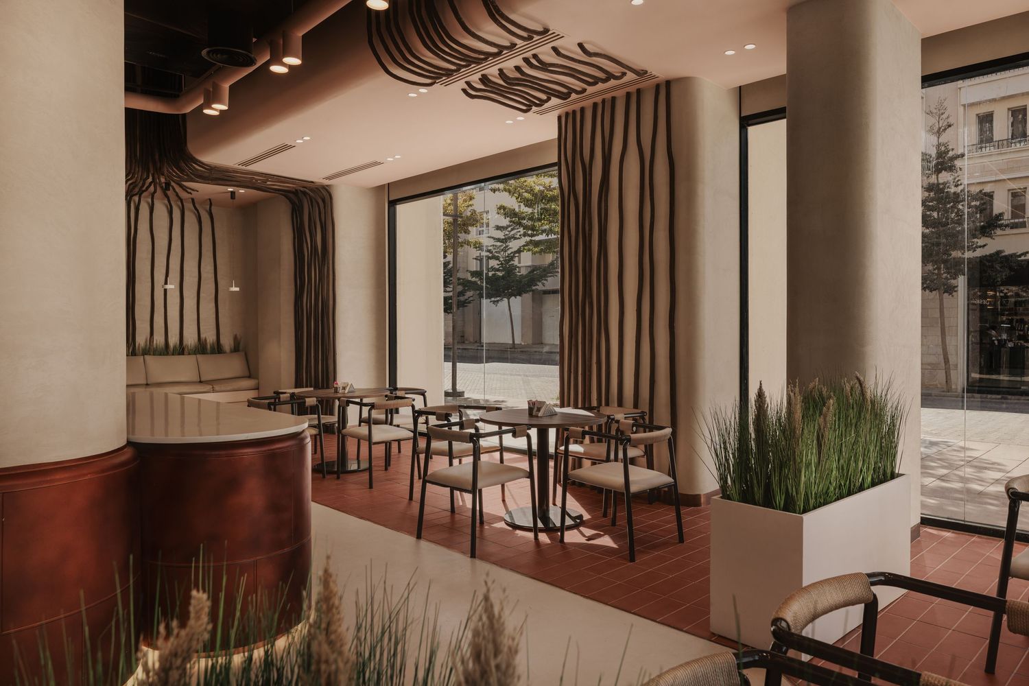 Modern restaurant interior with sculptural ceiling, warm earth tones, floor-to-ceiling windows, and elegant dining furniture.