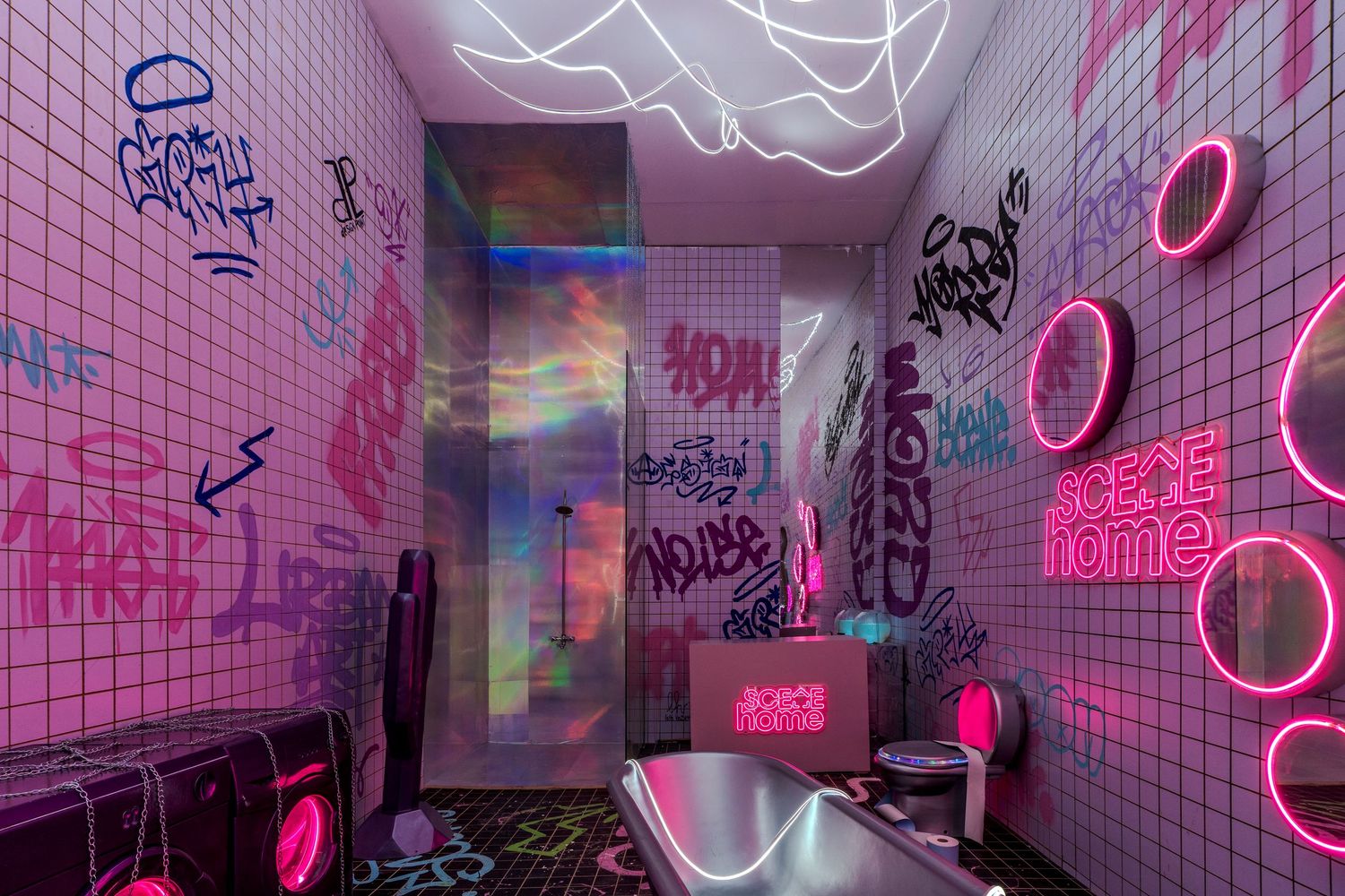 Neon pink graffiti bathroom with glowing rings and LED light strips on white tiled walls.