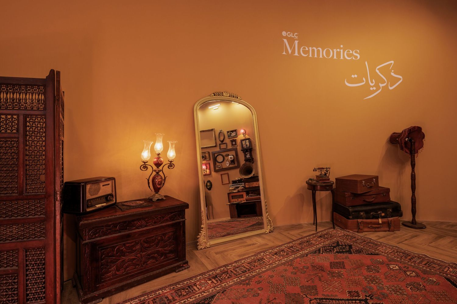 Cozy vintage room with Memories wall text, ornate wooden dresser, Persian rug, and antique mirror.