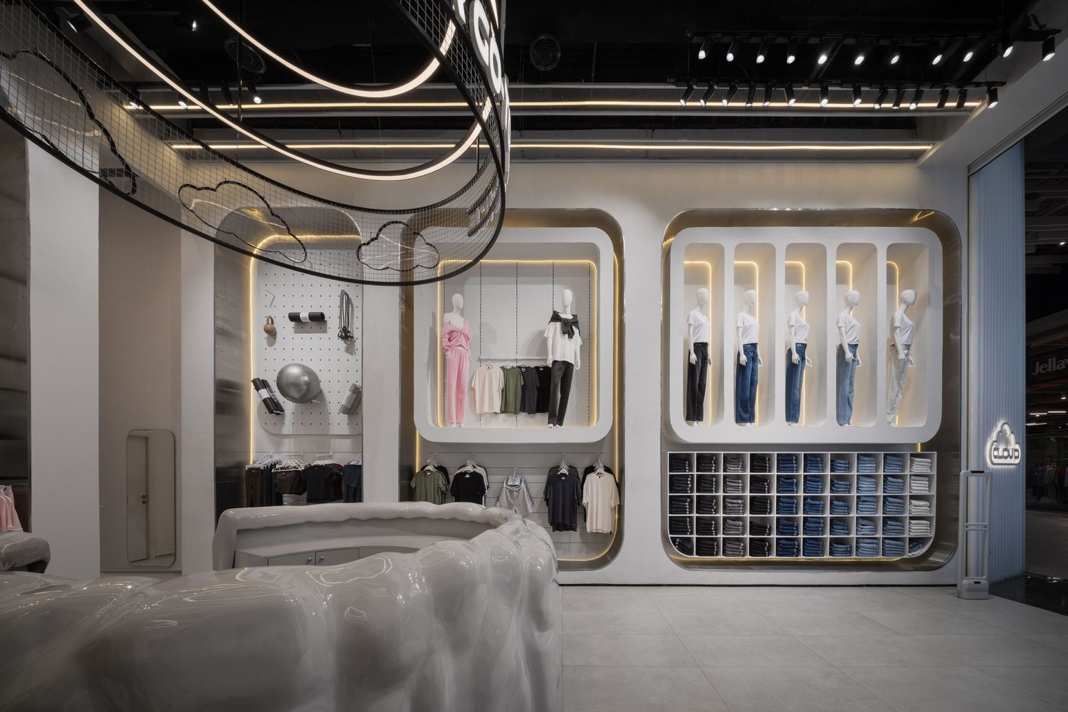 Futuristic retail store interior with gold display frames, white shelving units, and curved ceiling details.
