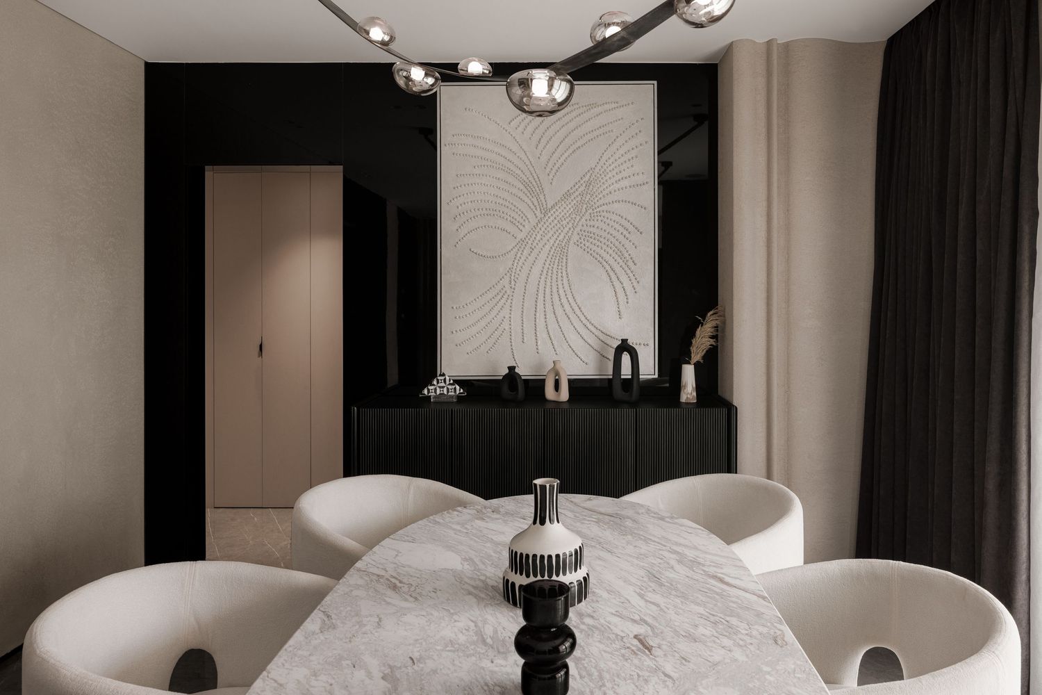 Elegant dining room with marble oval table, white curved chairs, black sideboard, and decorative wall art panel.
