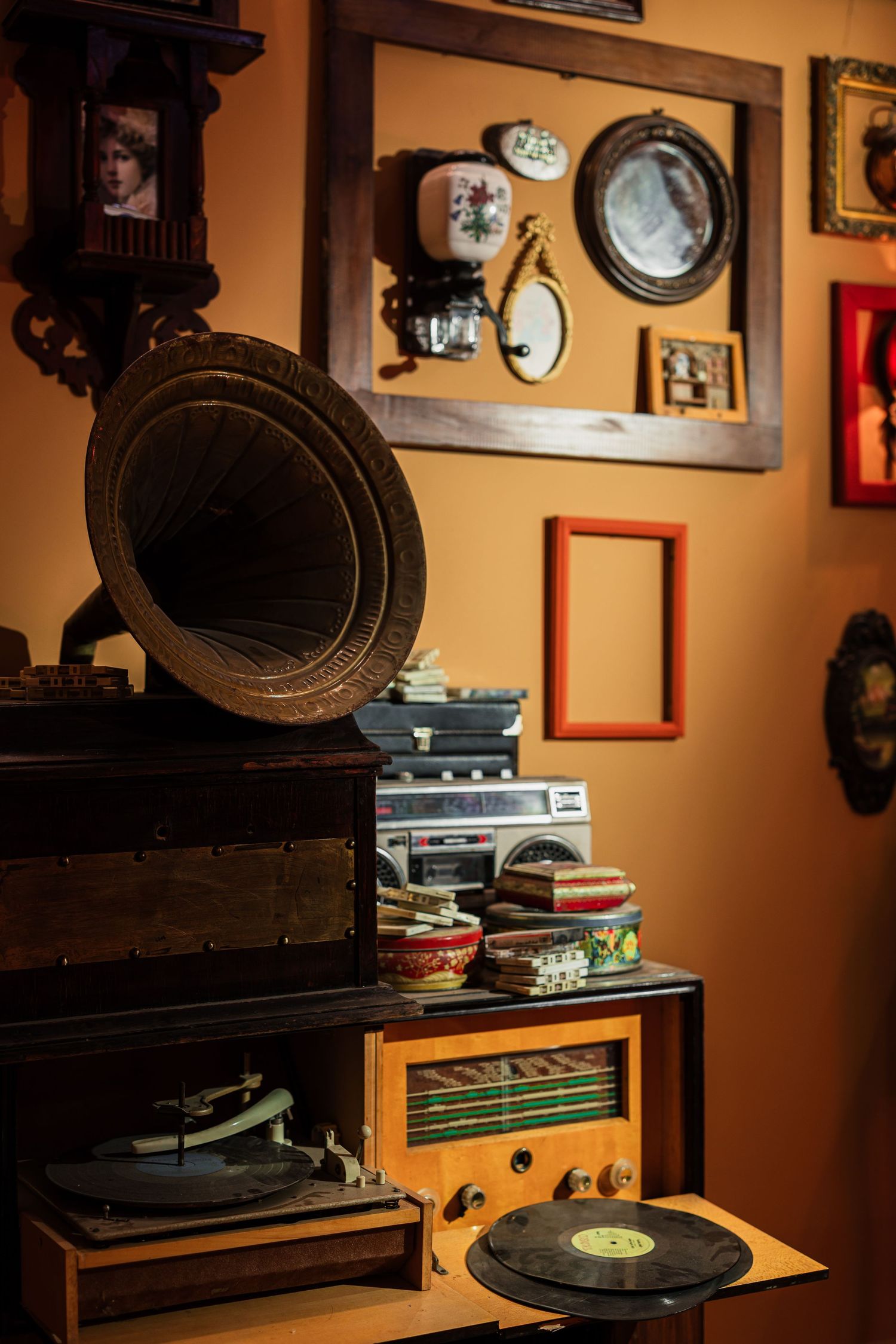 Vintage retro room with antique gramophone, vinyl records, old radio, and nostalgic wall decor on orange wall.