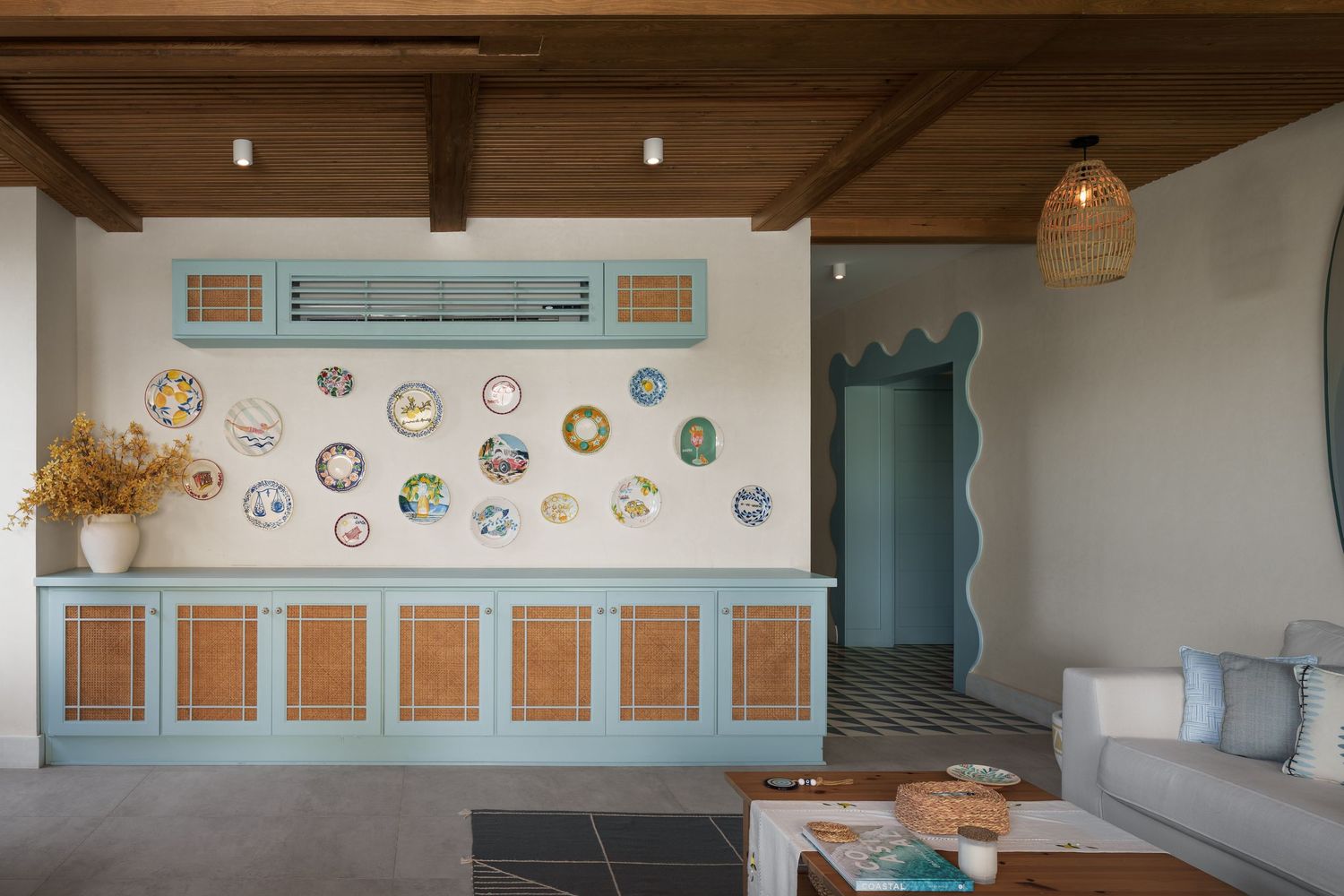 Mediterranean-style interior with blue cabinetry, decorative wall plates, rattan accents and wavy architectural details.