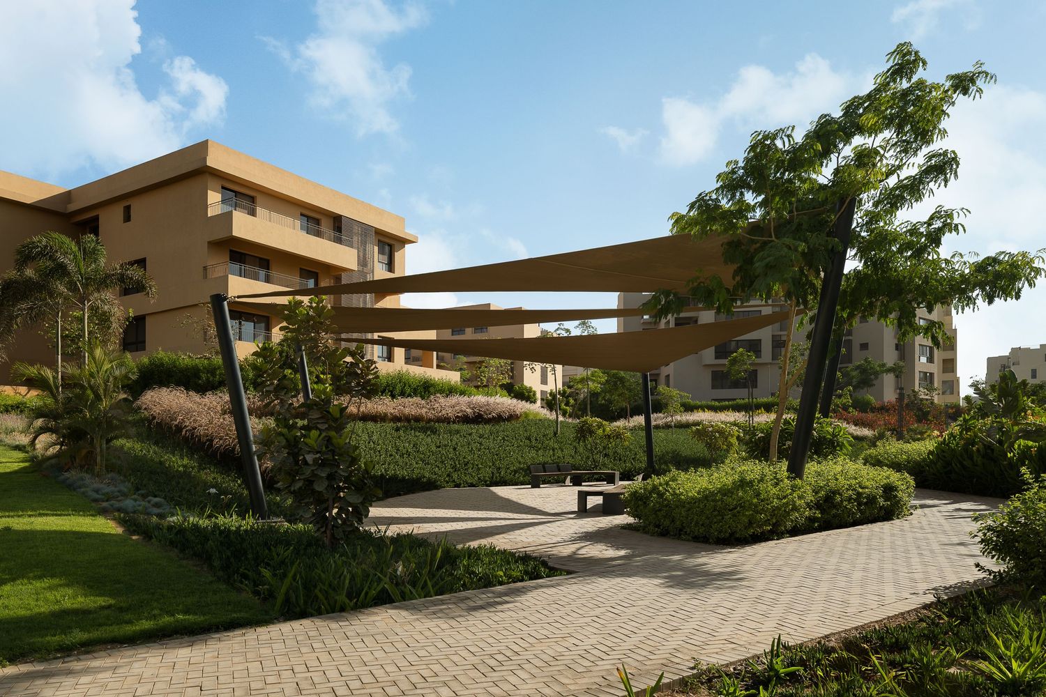 Shaded outdoor seating area with triangular sail canopies amid tropical landscaping in a modern residential community.
