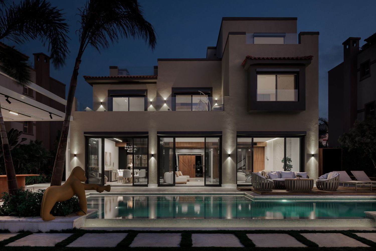 Luxury villa at night featuring a illuminated swimming pool, modern architecture, and lush tropical landscaping.