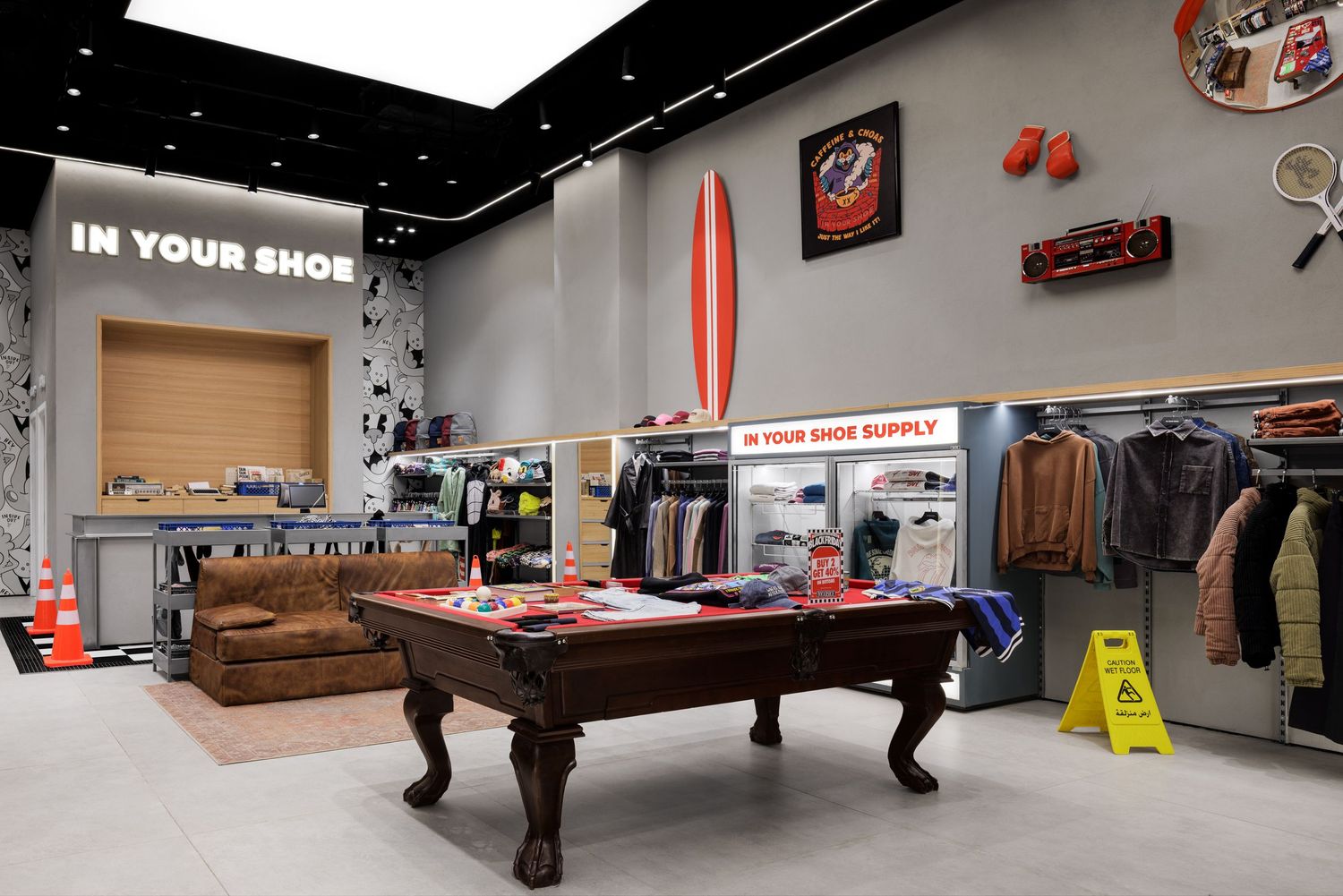 In Your Shoe store interior featuring pool table, surfboard wall decor, and clothing displays.