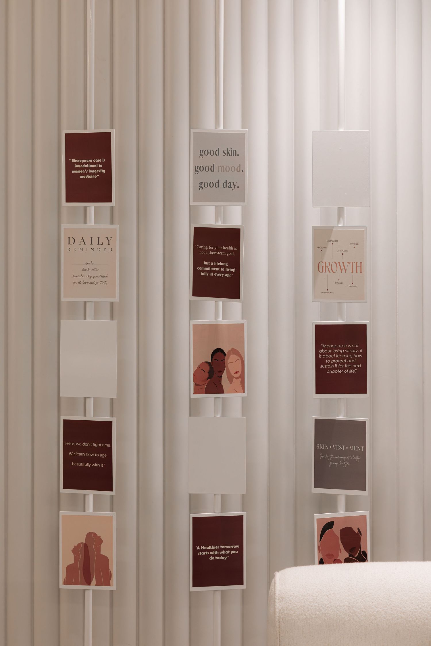 Decorative wall display of wellness and beauty motivational cards arranged between white fluted panels.