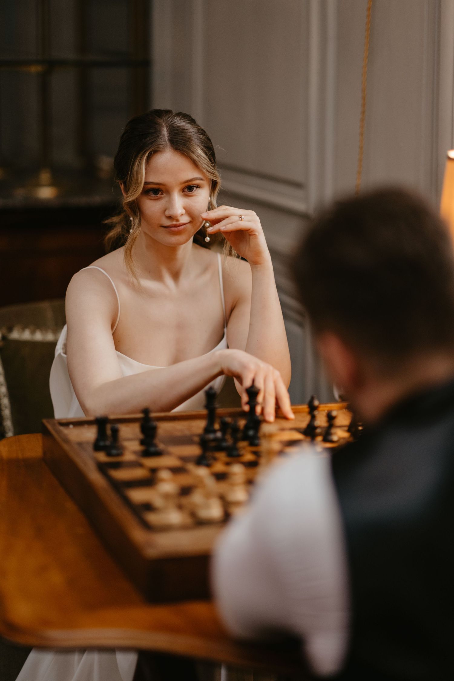 Candid portrait of a chess match in a warmly lit interior space.