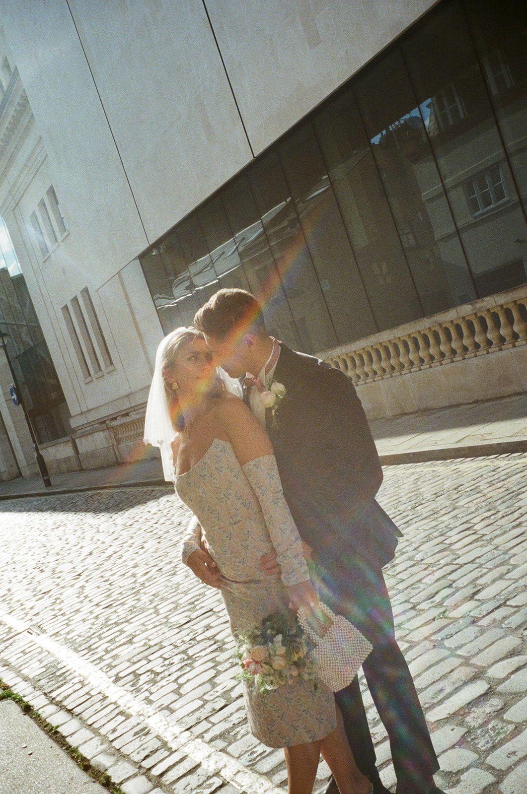 A romantic sunlit moment on a cobblestone street with lens flare effects at old Marylebone town hall