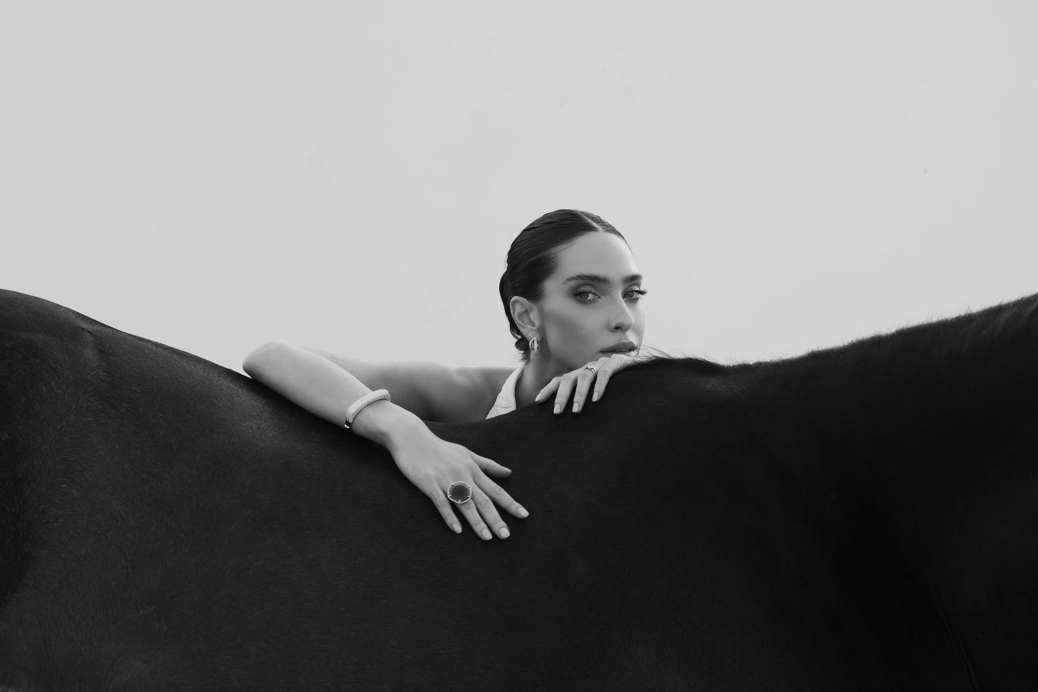 Black and white photo sequence showing a hand sliding across a dark surface in a minimalist artistic style.