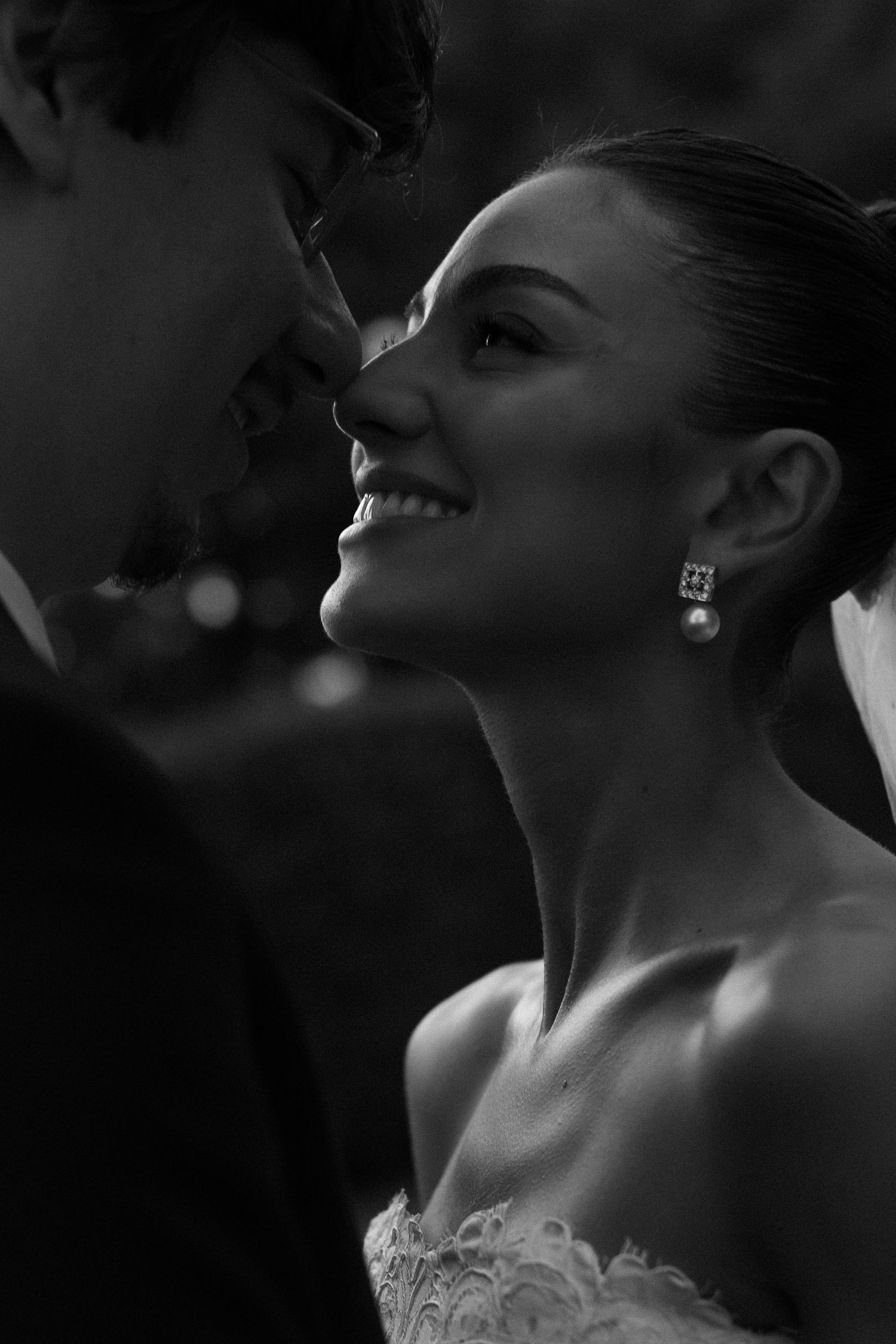 Black and white profile portraits showing elegant bride with upswept hair and earrings in dramatic lighting.