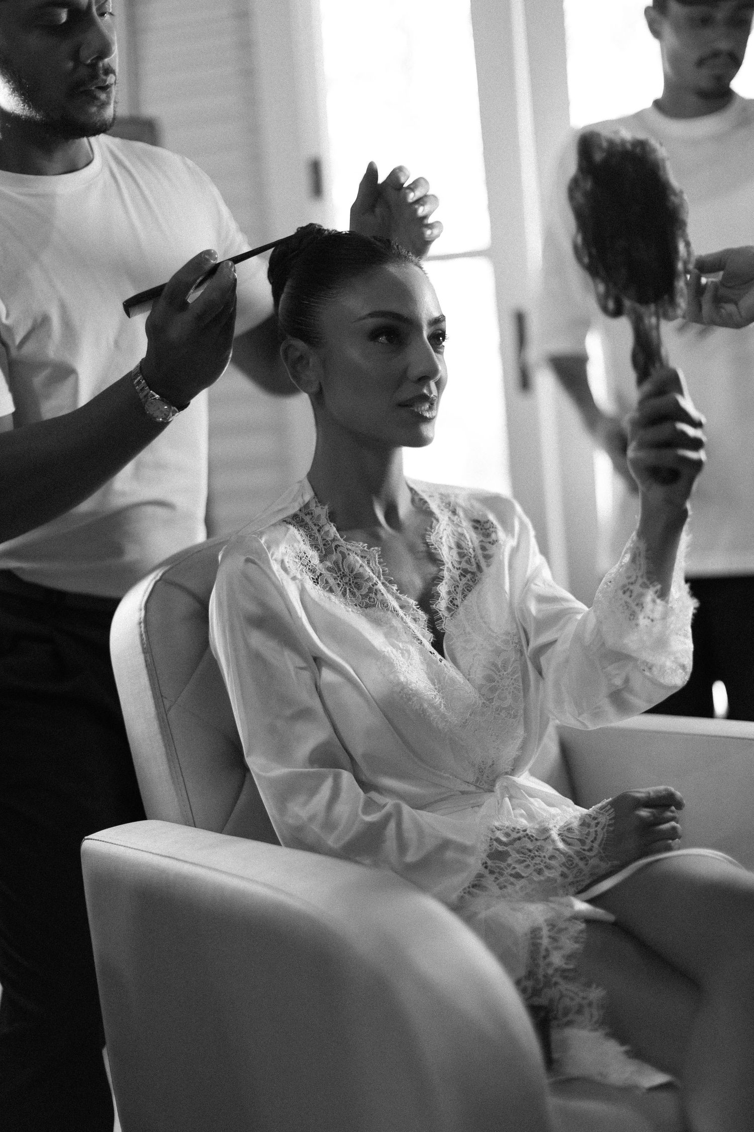 A sequence of black and white photos showing someone in a white lace dress seated on a couch in different poses.