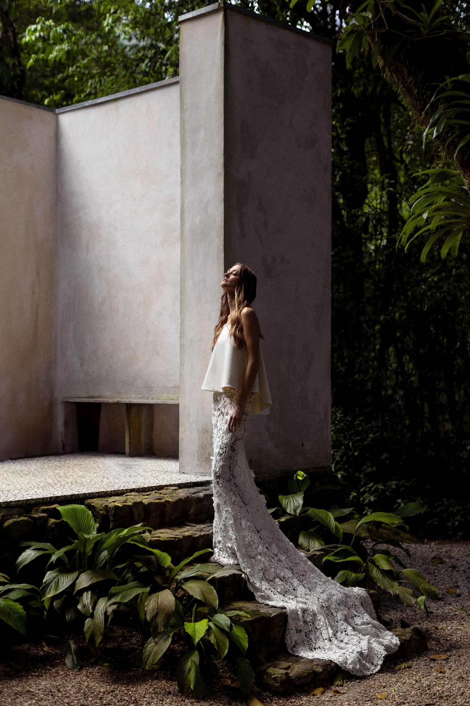 A series of four bridal portraits showing someone in a lace wedding dress against white walls and tropical foliage.