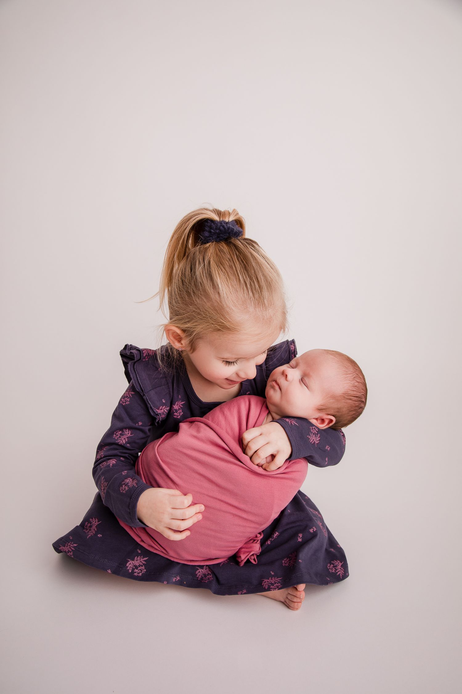Foto van trotse grote zus met haar pasgeboren baby zusje