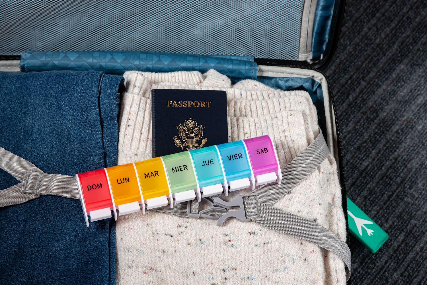 Product shot of a pill organizer in a suitcase packed for travel