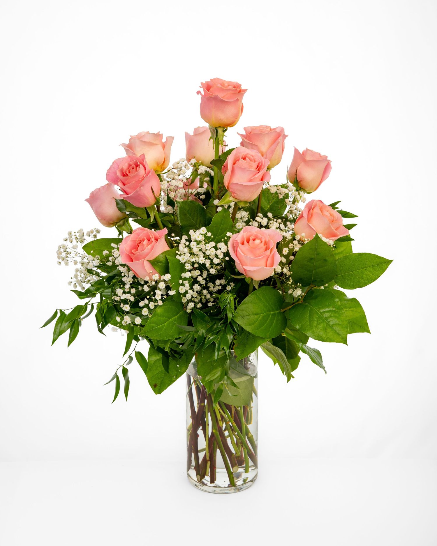 Two dozen blush pink roses in a glass vase.