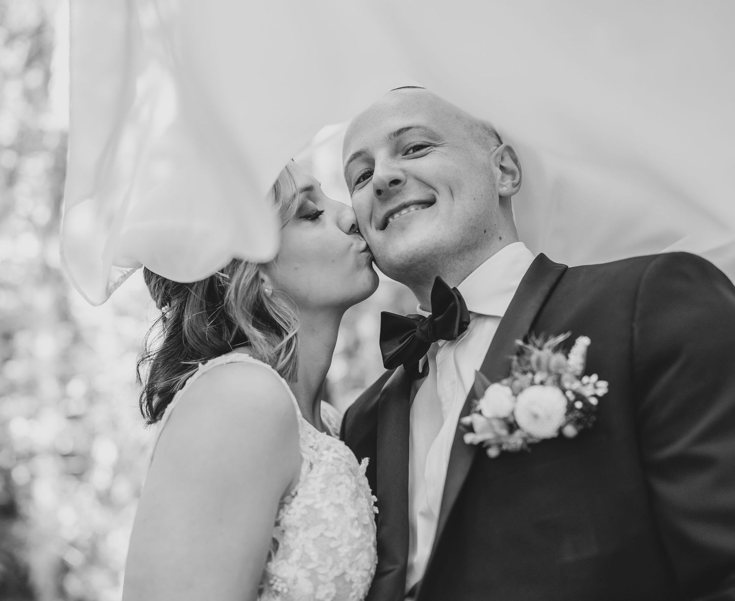 A tender black and white wedding portrait capturing an intimate moment between newlyweds.