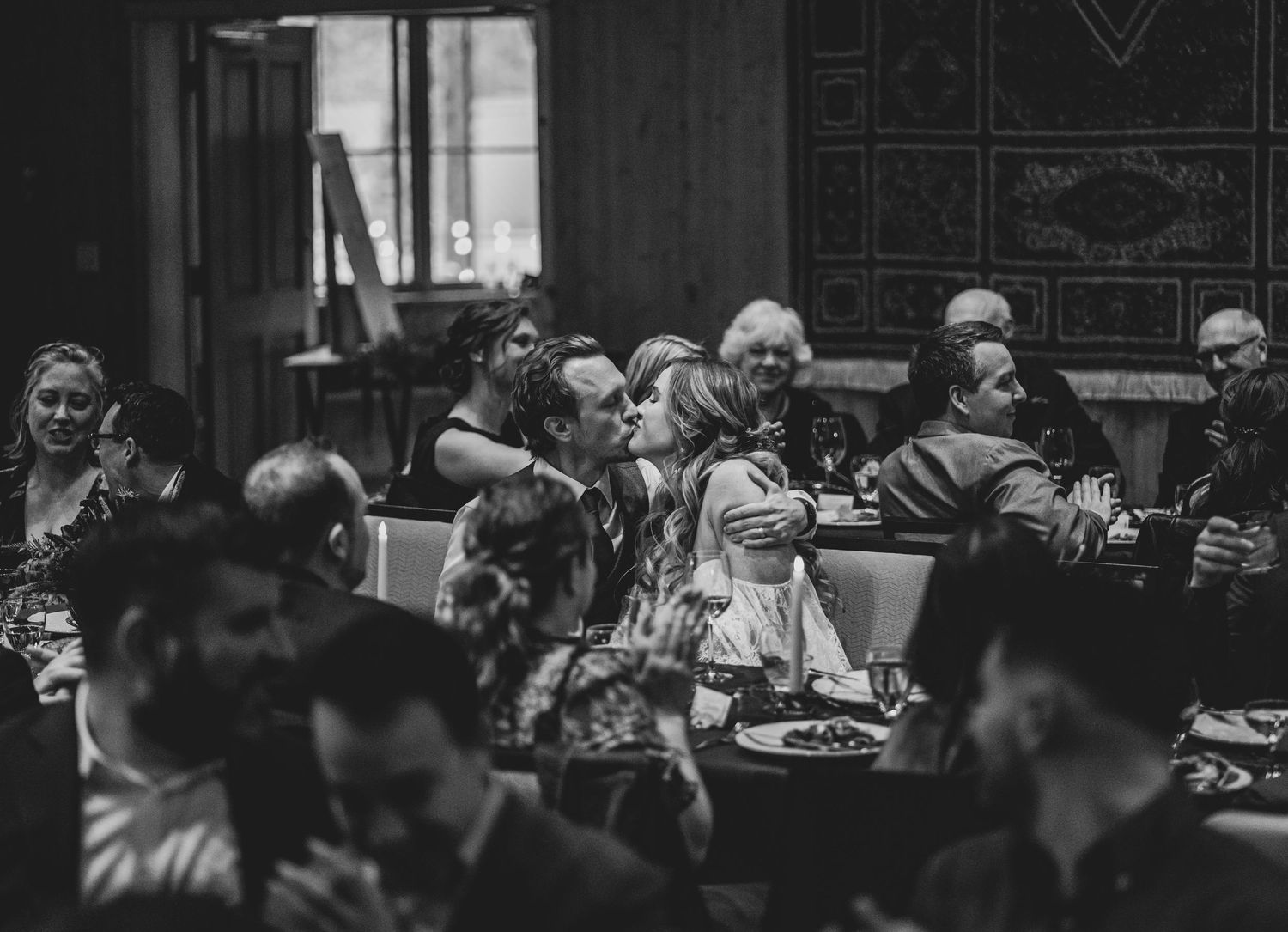 Wedding reception guests enjoying a lively celebration in a dimly lit venue.