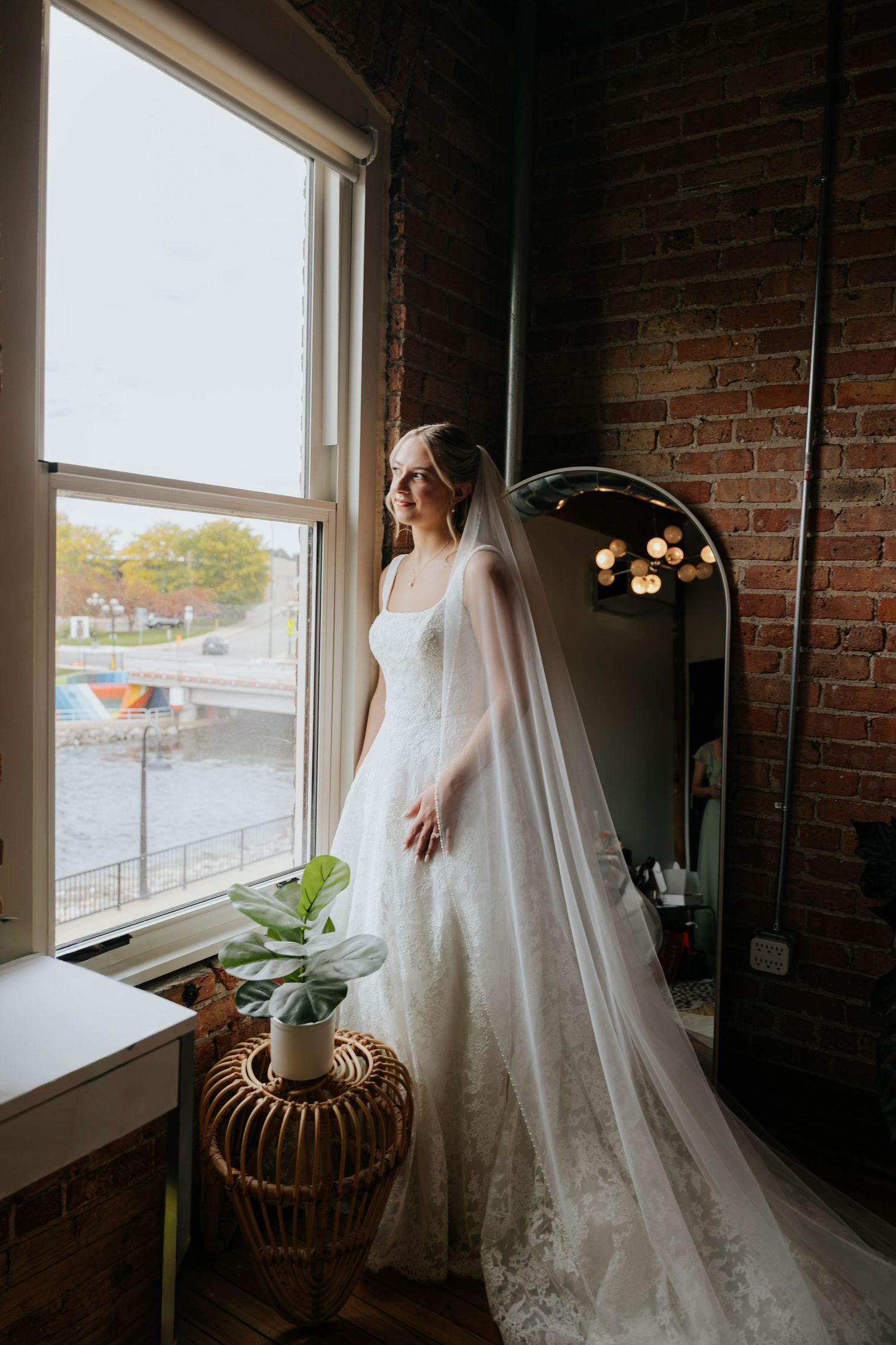 Elegant bridal portrait by a window at Record Box Loft in Battle Creek, Michigan, featuring a flowing wedding veil and natural light.