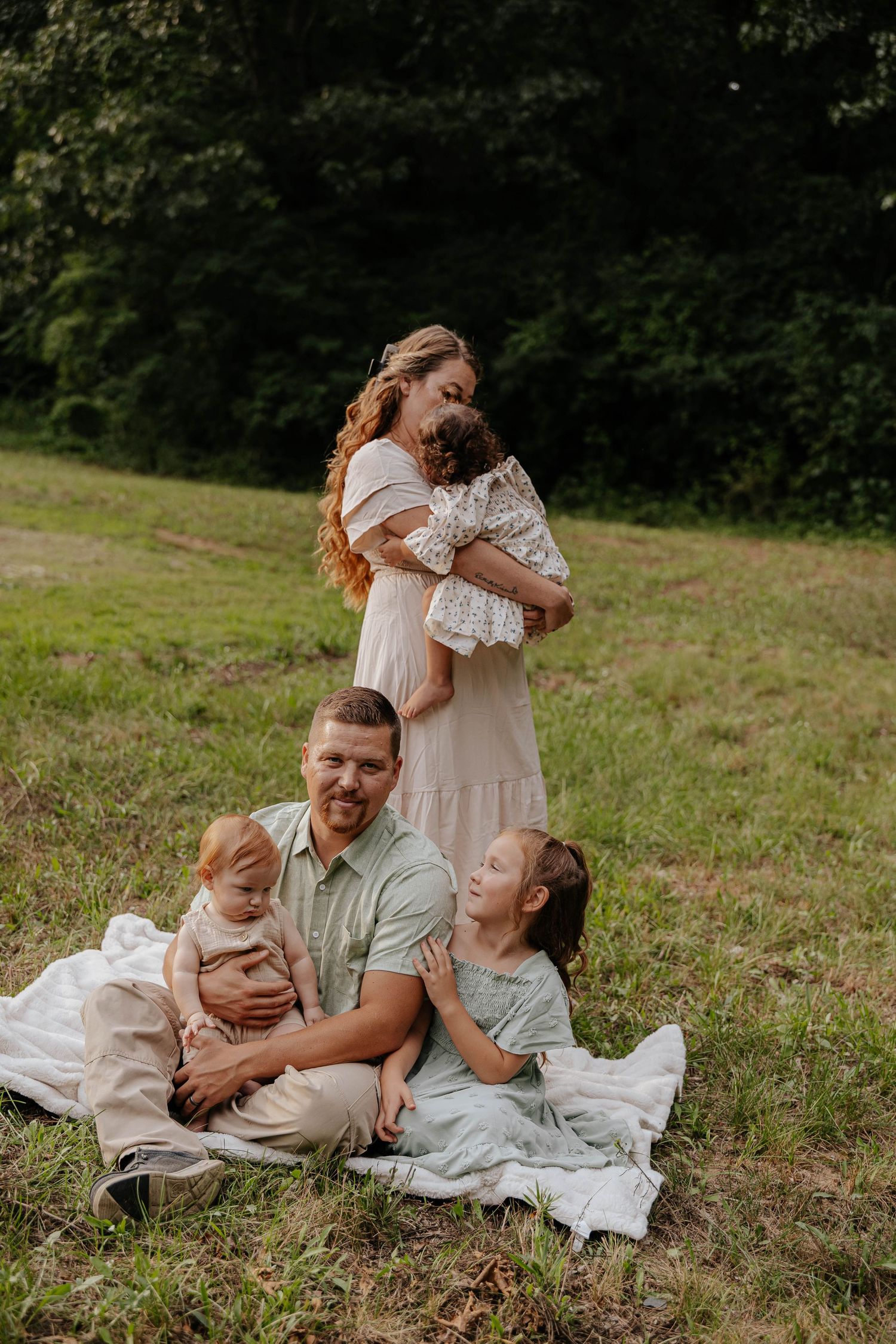 Outdoor family portrait of a mother and her children sitting together in a grassy field in Battle Creek, Michigan.