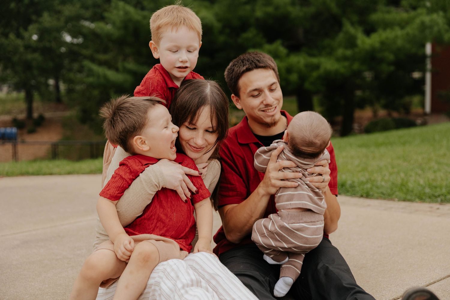 Family of five cuddles together during a candid outdoor family photography session in Kalamazoo, Michigan.