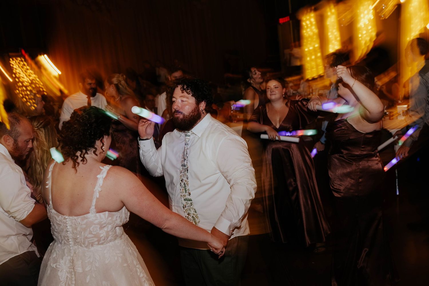 Candid wedding reception photography of newlyweds dancing with their guests at Bowen Mills in Middleville, Michigan.