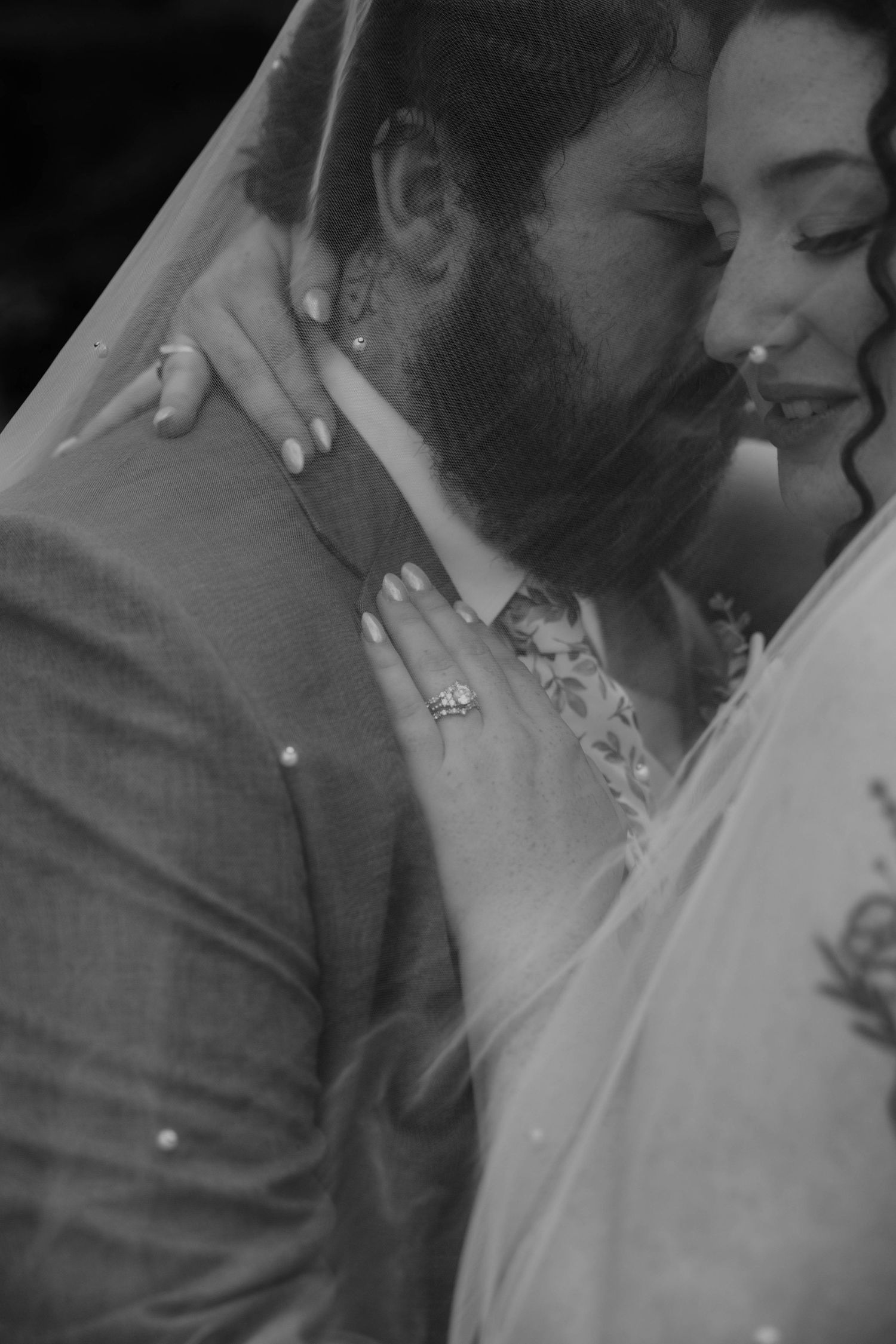 Intimate black-and-white close-up of a bride and groom embracing on their wedding day at Bowen Mills in Middleville, Michigan.