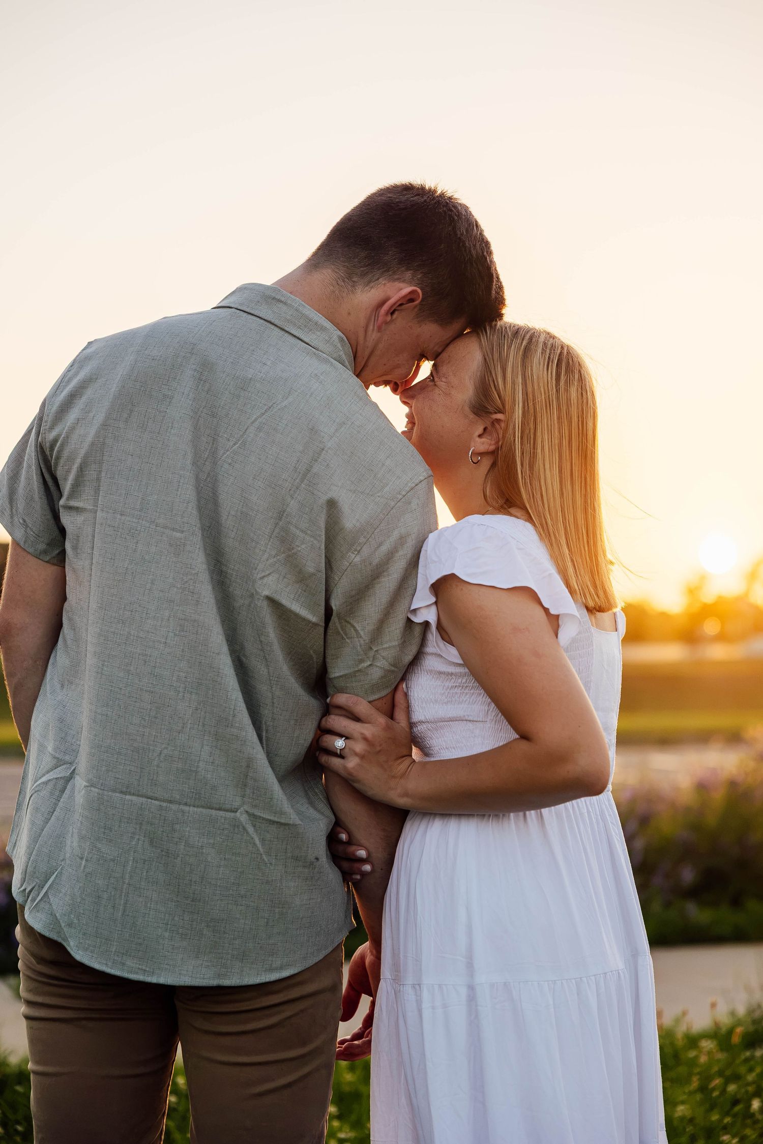 Romantic sunset engagement portrait of a couple embracing in a field near Kalamazoo, Michigan.