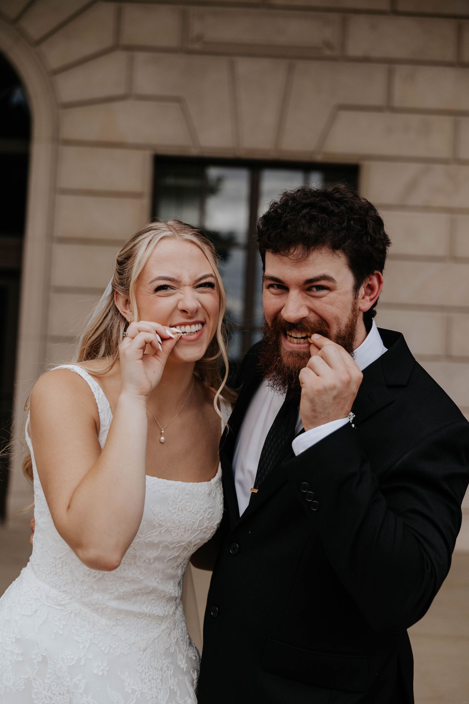 Bride and groom share a playful moment together in their wedding attire during a wedding celebration in Battle Creek, Michigan.