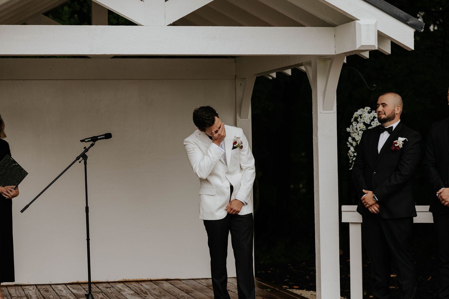 Emotional wedding ceremony moment as a groom wipes away tears while waiting for his bride in Battle Creek, Michigan.